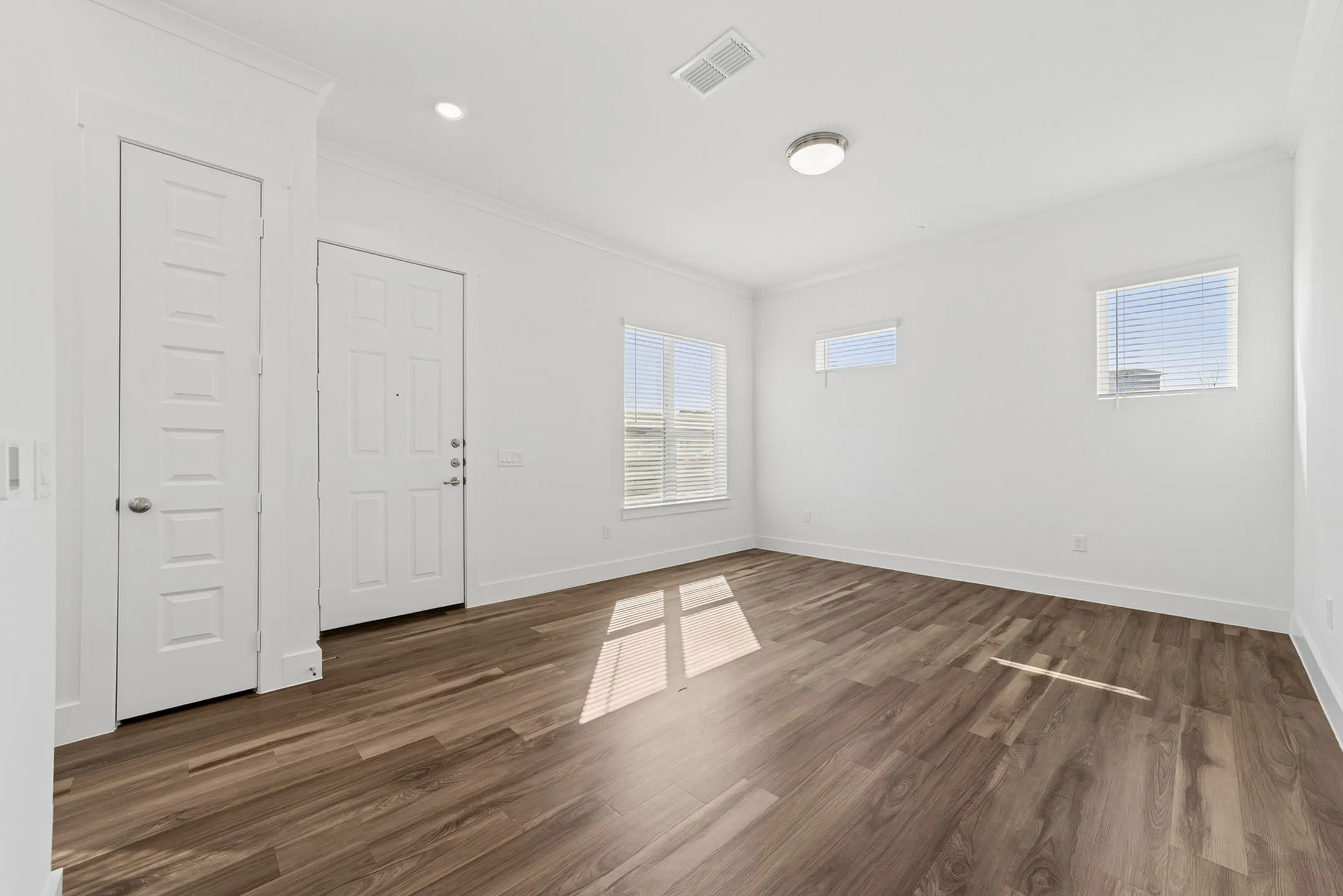 Bright and welcoming living space with elegant hardwood floors and ample natural light.