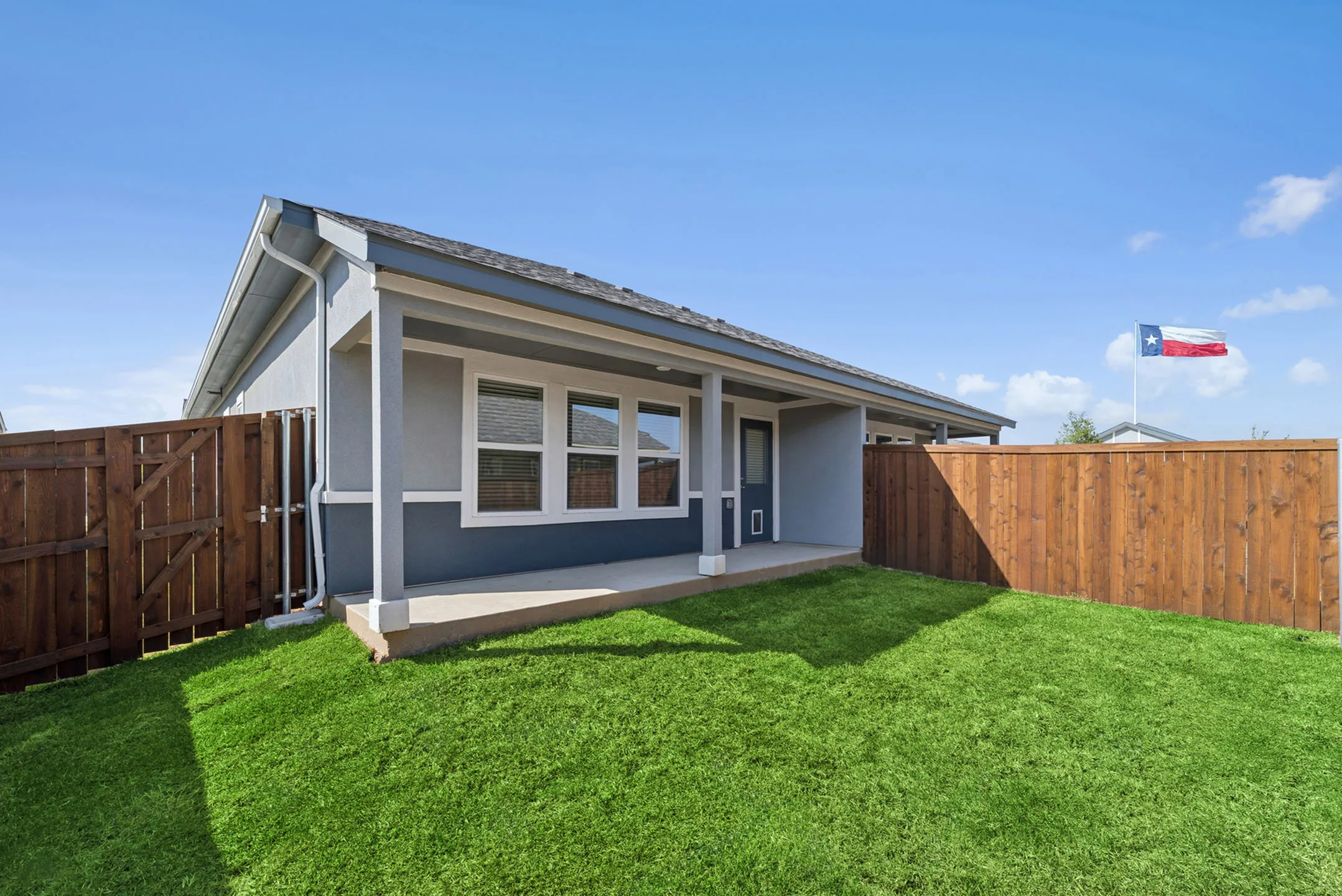 Charming backyard with a well-kept lawn and a cozy covered patio, perfect for relaxation and gatherings.