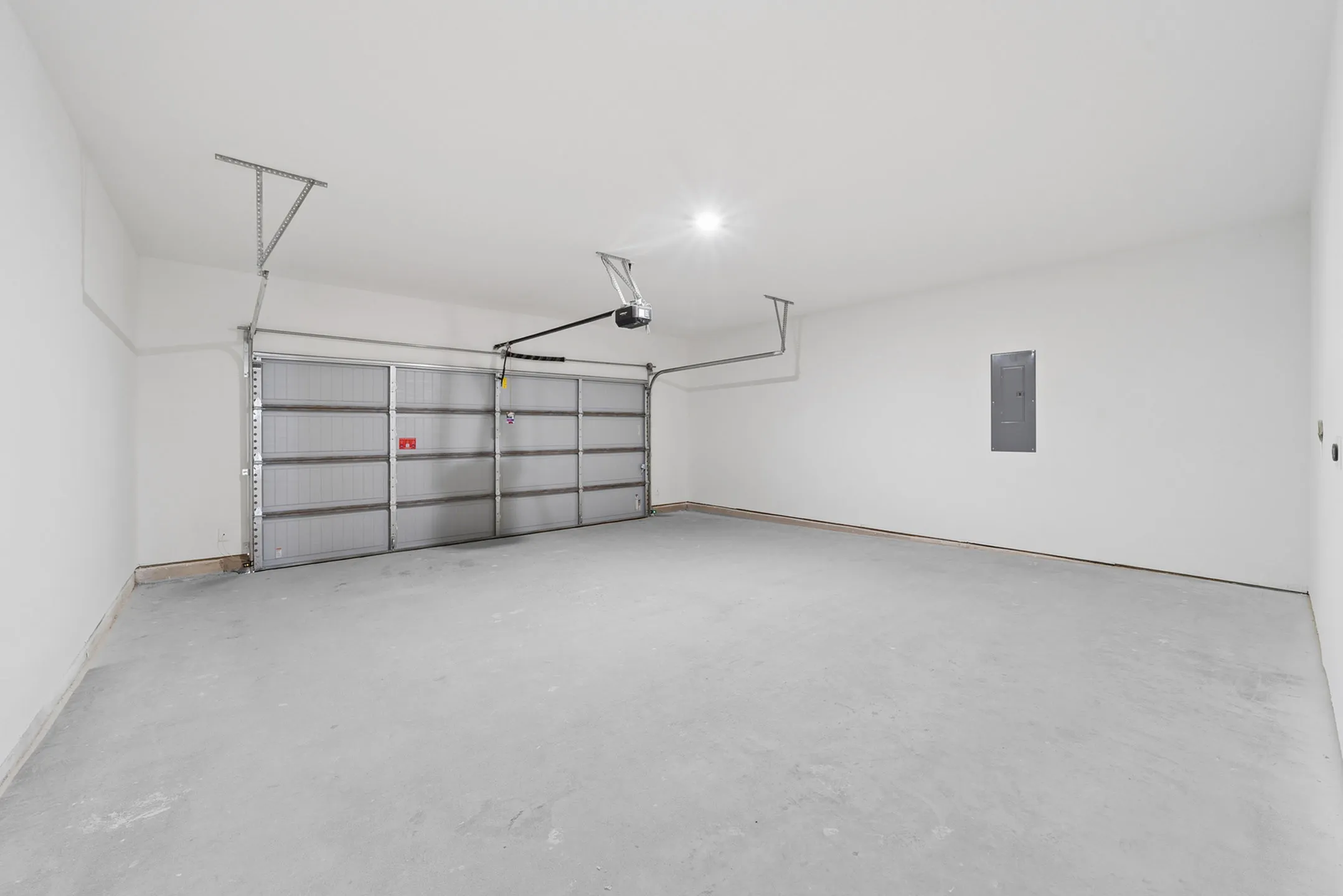 Spacious, clean two-car garage with modern overhead door and bright lighting.