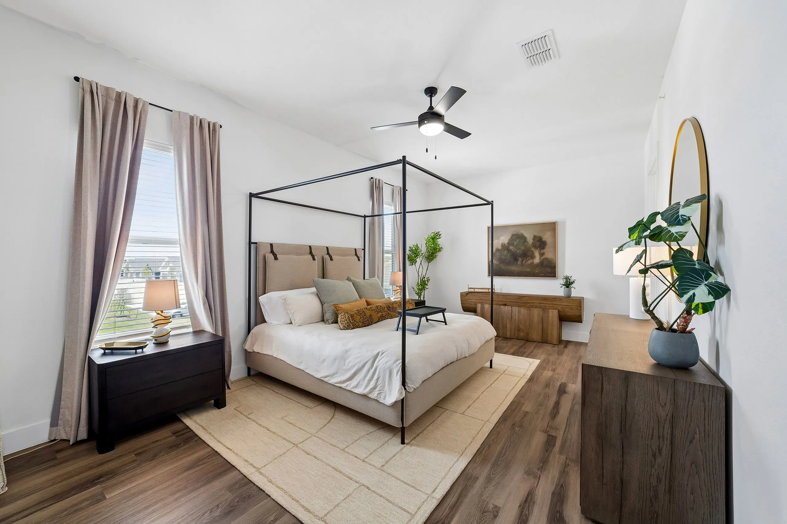 Elegant bedroom with a canopy bed, stylish decor, and abundant natural light, perfect for relaxation and comfort.