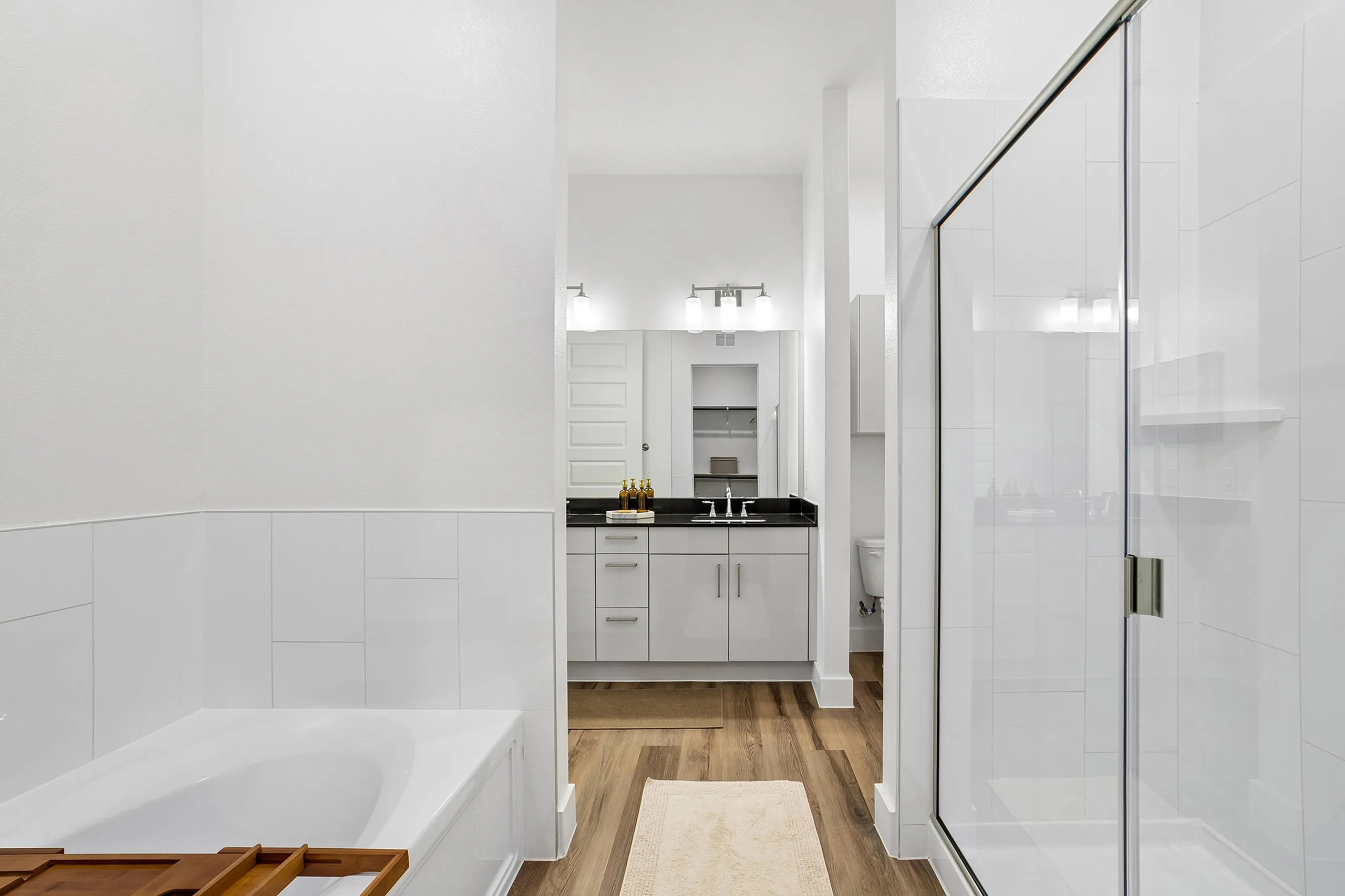 Luxurious modern bathroom featuring a sleek glass-enclosed shower, elegant vanity with double sinks, and a relaxing bathtub.