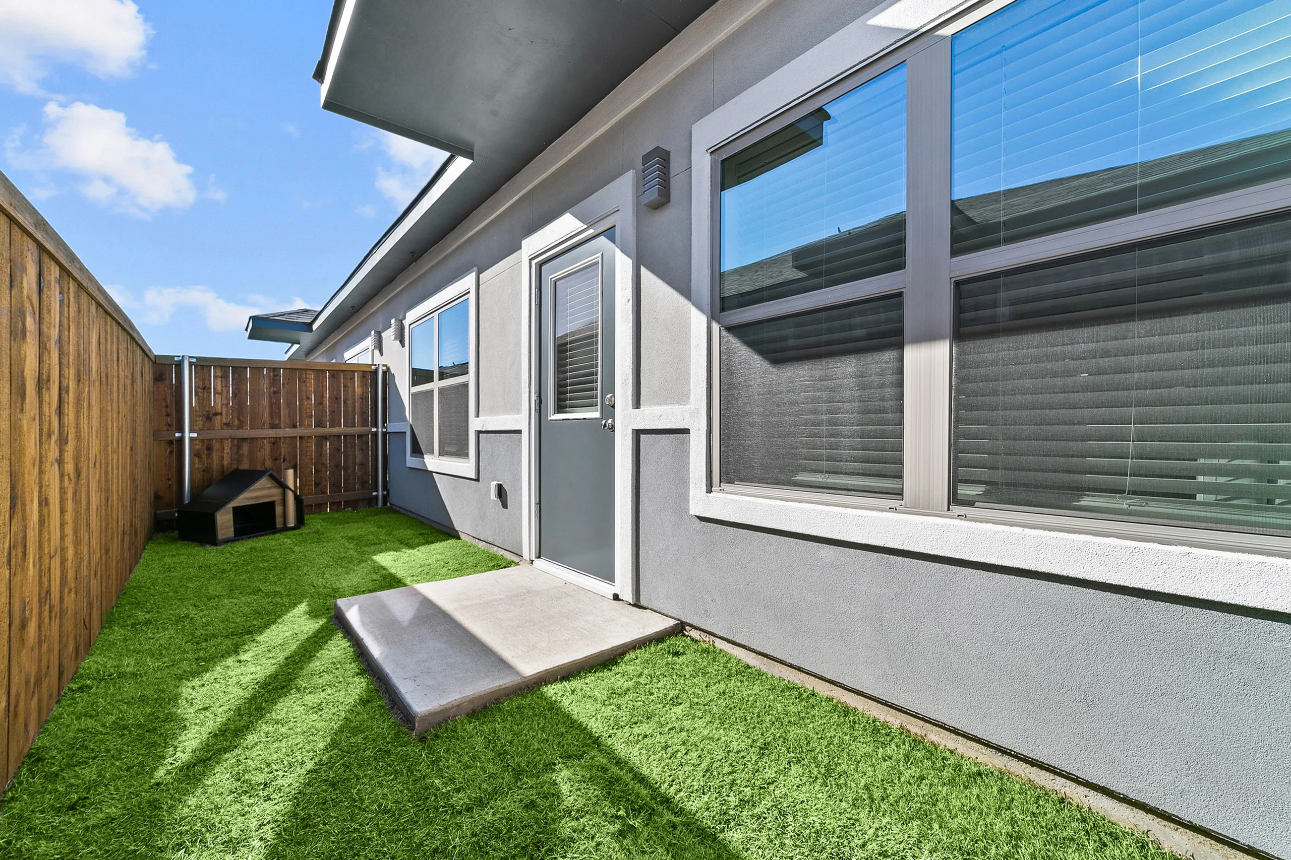 Charming private backyard with vibrant green grass and a wooden fence, perfect for relaxation and outdoor enjoyment.