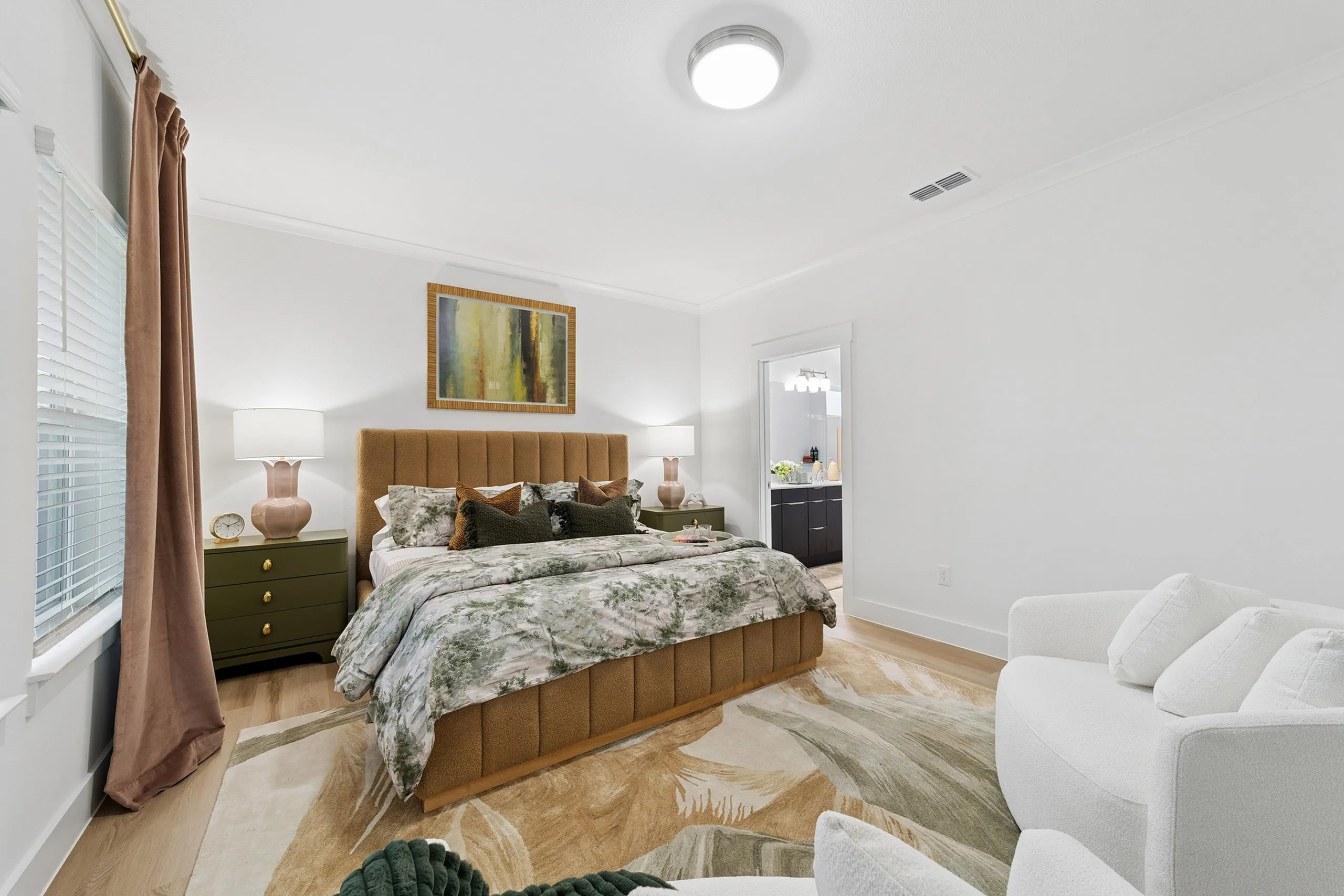Chic bedroom with plush bedding, contemporary decor, and en-suite bathroom, offering serene and stylish living space.