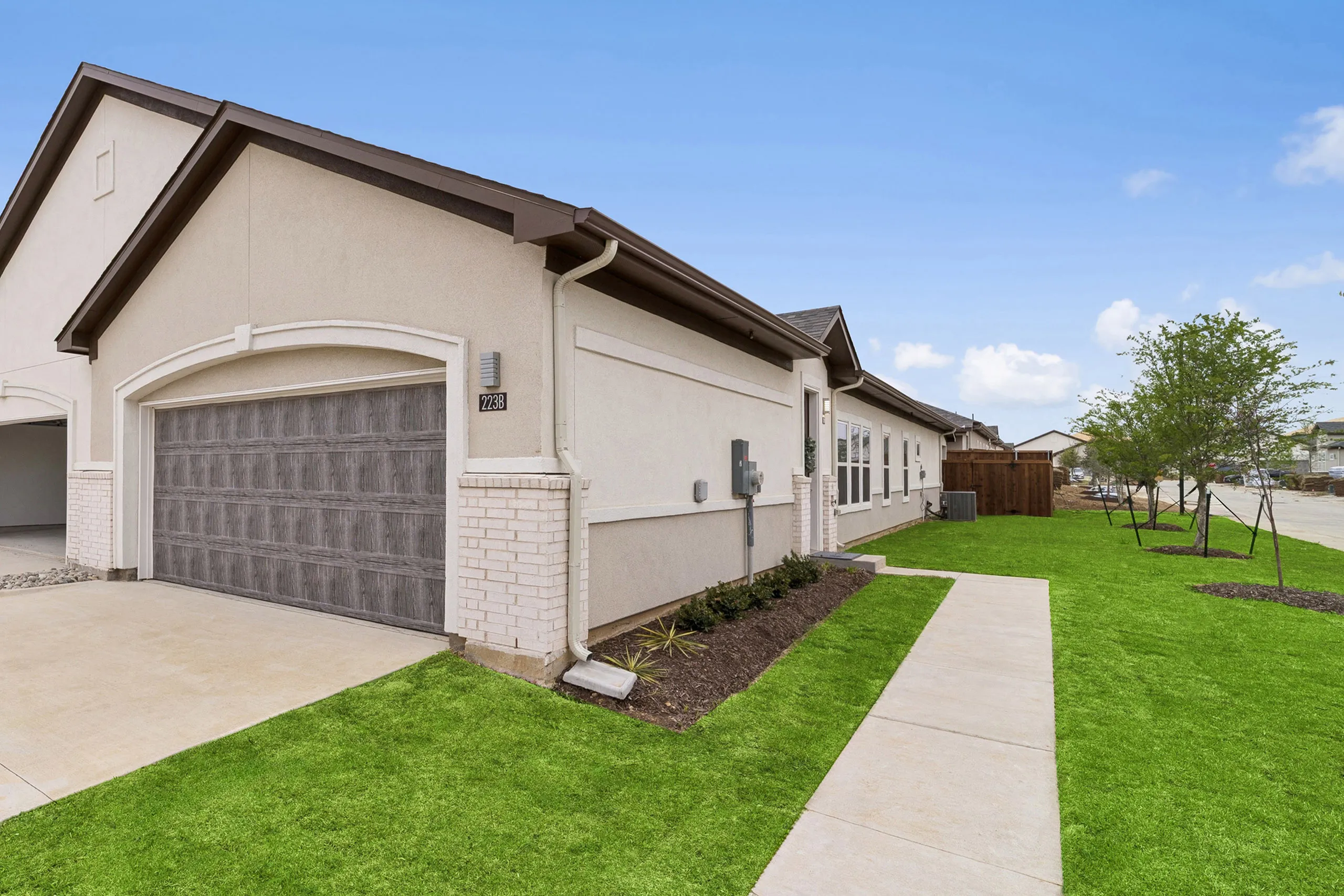 Charming suburban rental home with elegant garage, manicured lawn, and inviting neighborhood vibe.