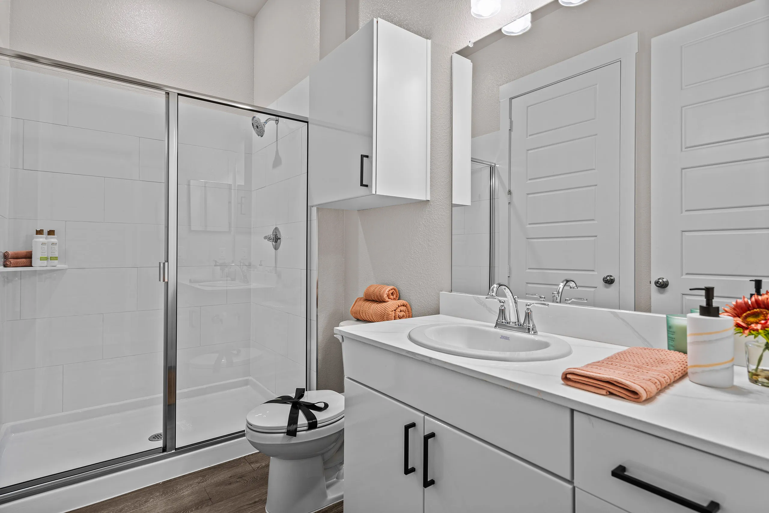 Modern bathroom with elegant glass shower, sleek white vanity, and stylish accents, creating a spa-like retreat.