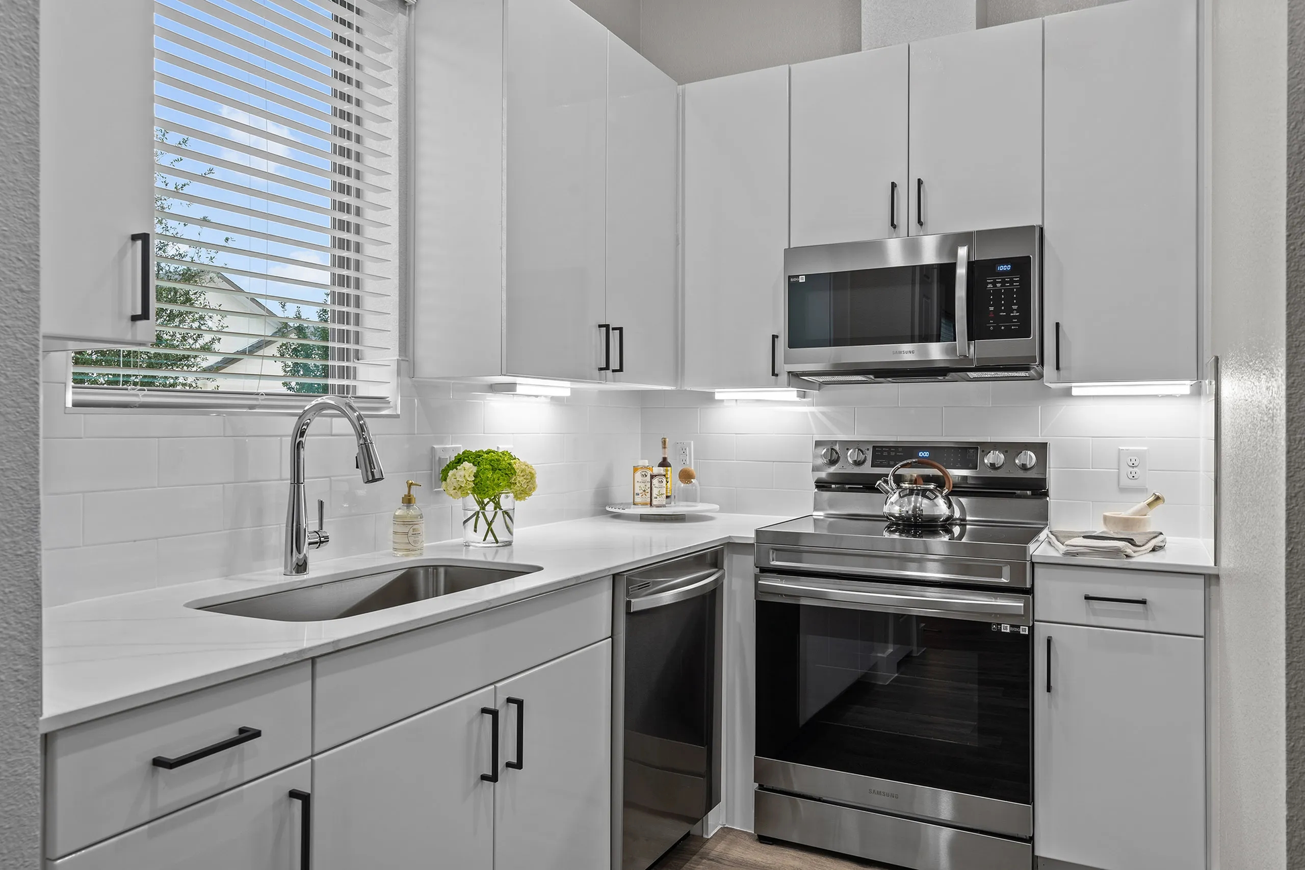 Modern kitchen with sleek white cabinetry, stainless steel appliances, and elegant countertop design.