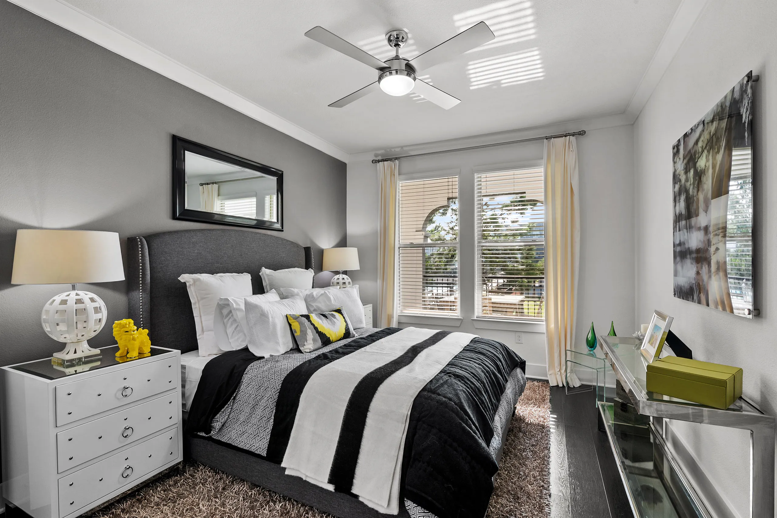 Elegant bedroom with contemporary decor, featuring a plush bed, stylish bedside lamps, and ample natural light through large windows.