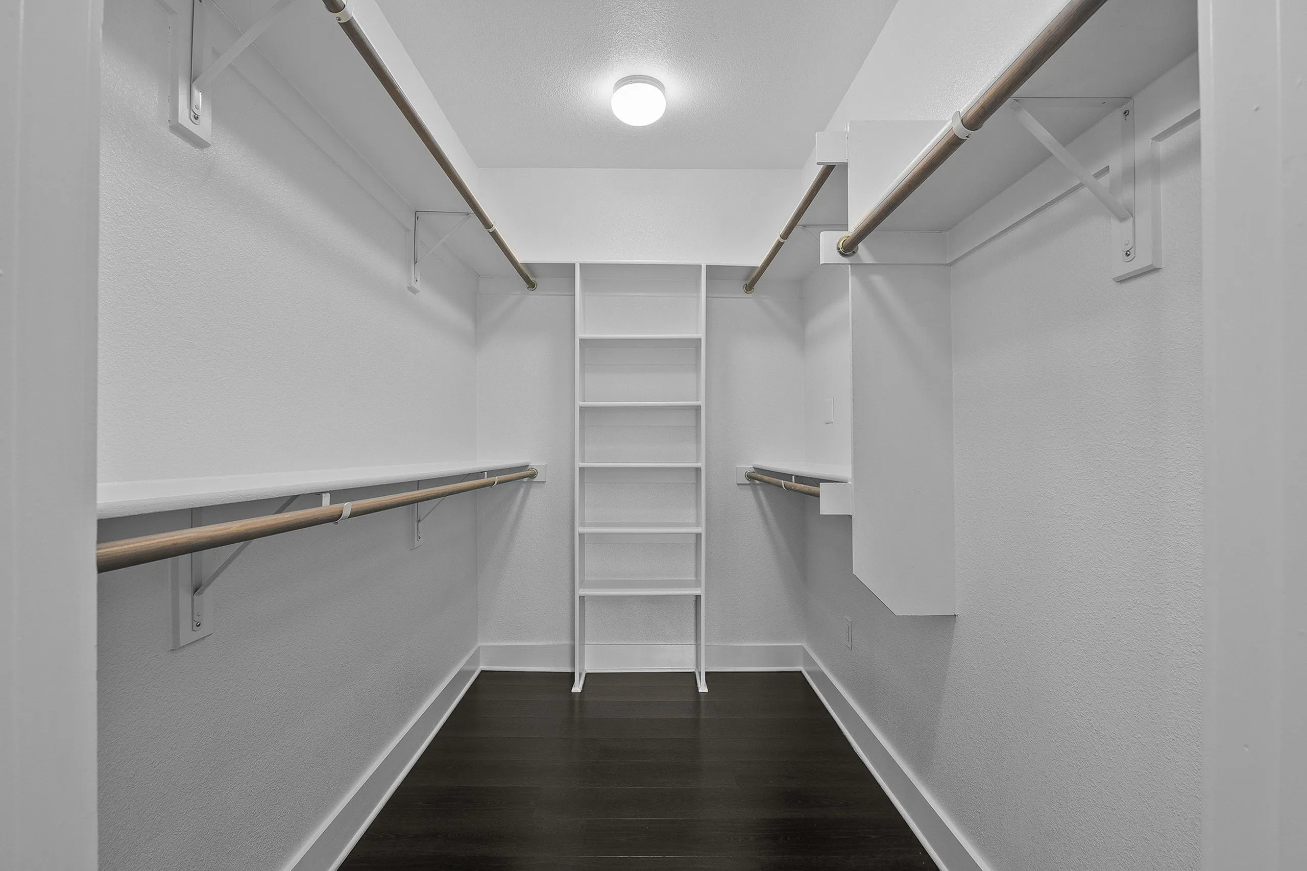 Spacious walk-in closet with ample hanging space and sleek shelving, perfect for organized storage.