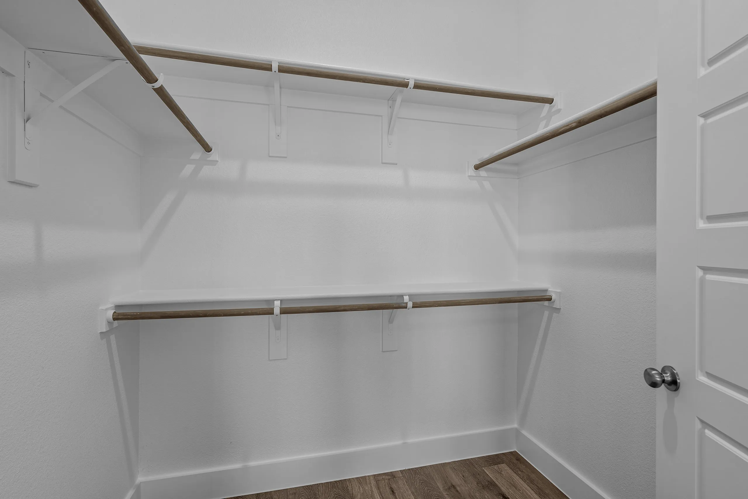 Spacious walk-in closet with elegant wooden shelving and ample storage space.