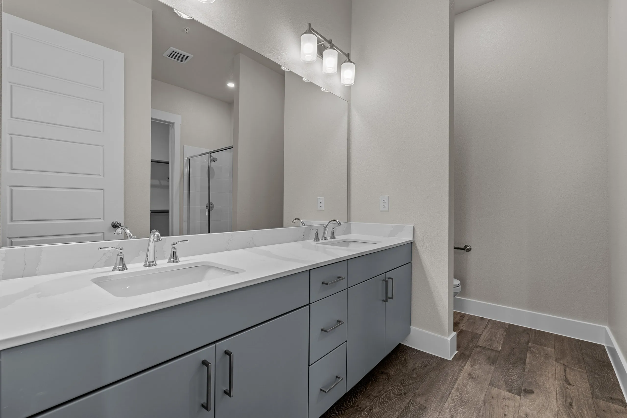 Elegant bathroom with double vanity, sleek gray cabinets, and modern fixtures set against a tranquil neutral palette.