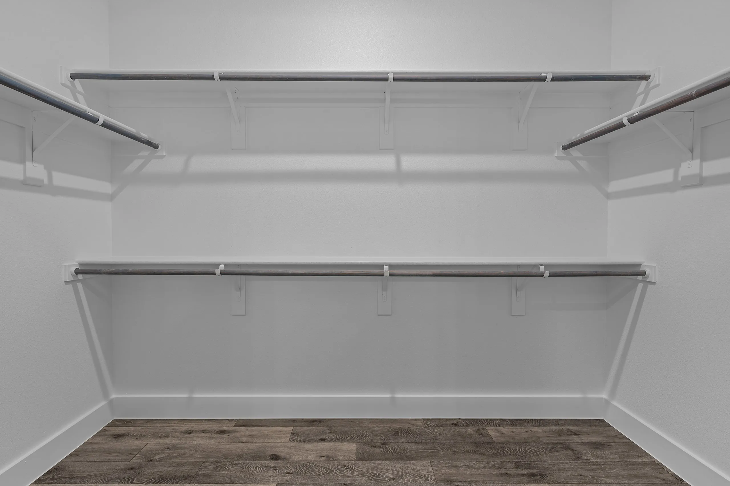 Spacious walk-in closet with sleek shelving and modern flooring.