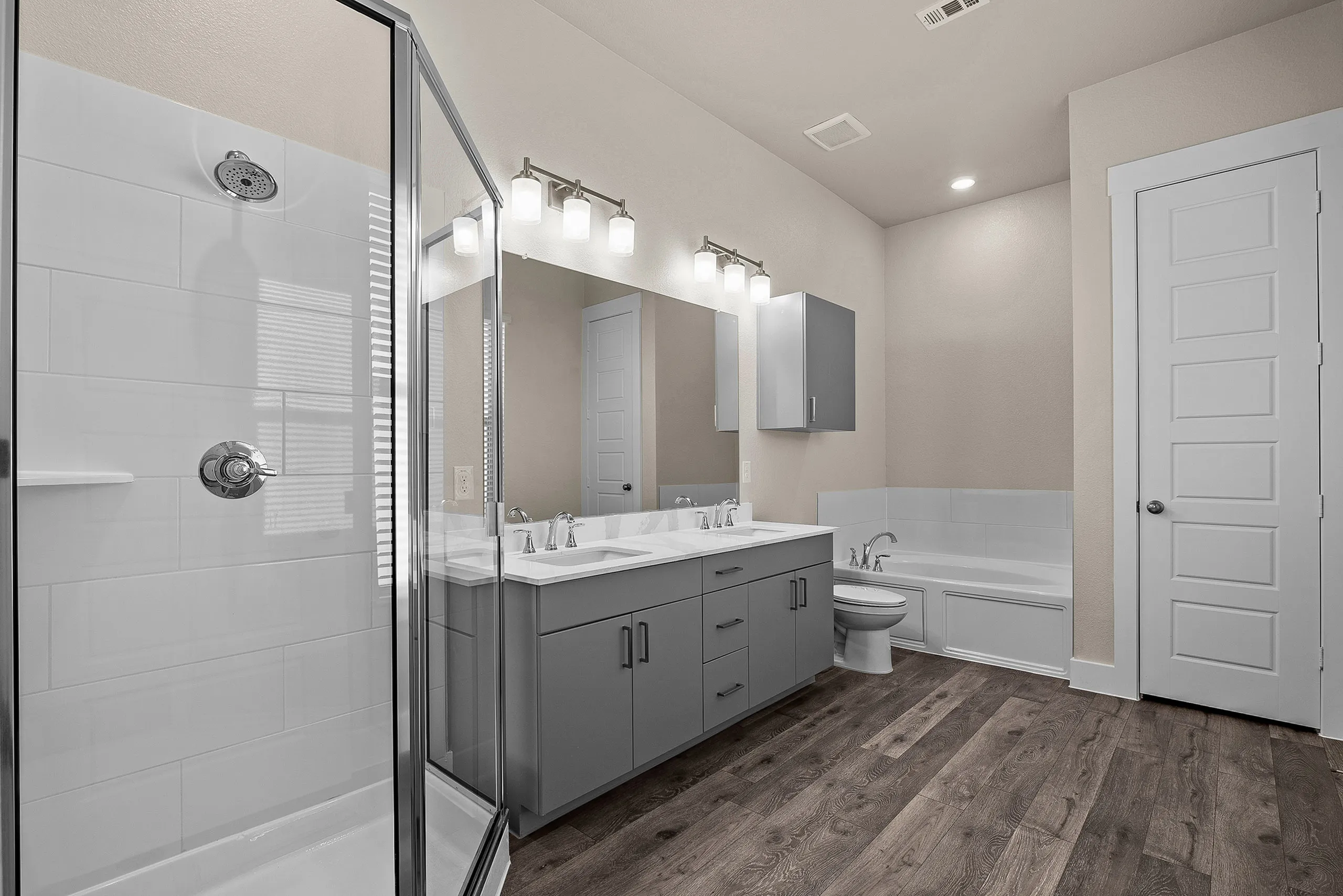 Elegant modern bathroom featuring a glass shower, spacious double vanity with sleek cabinetry, and a luxurious soaking tub.