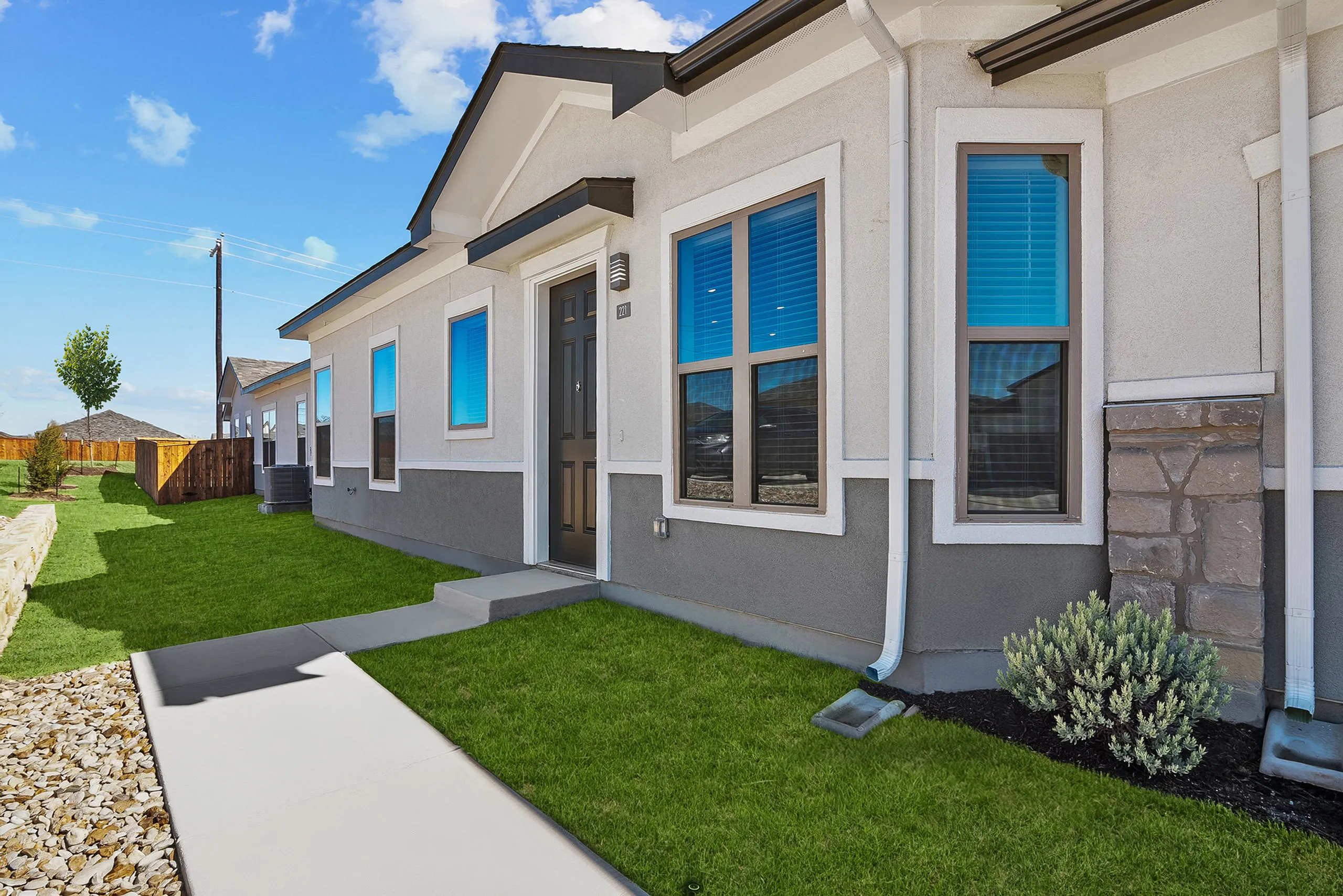Contemporary home exterior with charming facade, large windows, and well-maintained landscaping.