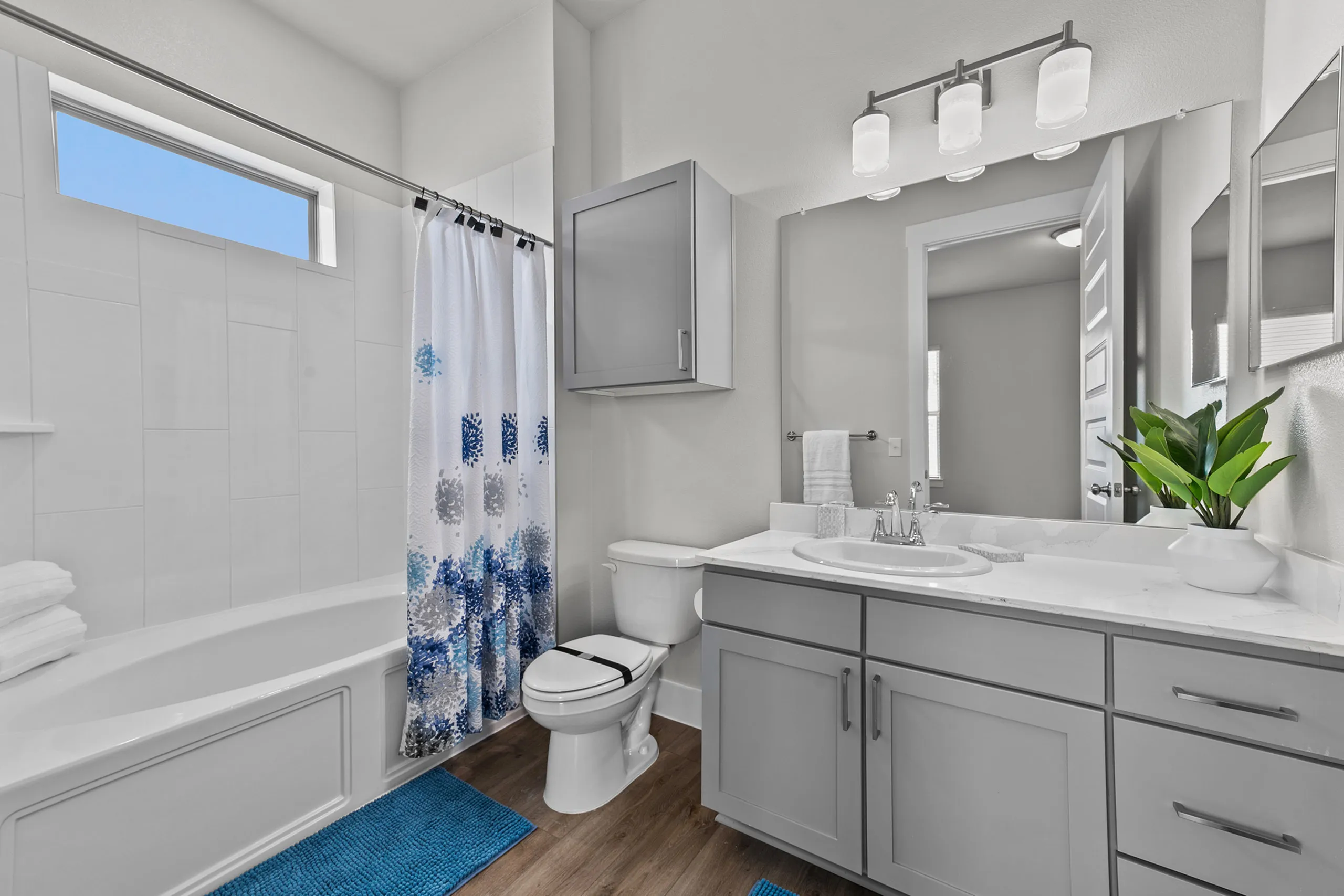 Chic bathroom design with modern fixtures, elegant gray cabinetry, and stylish blue accents.