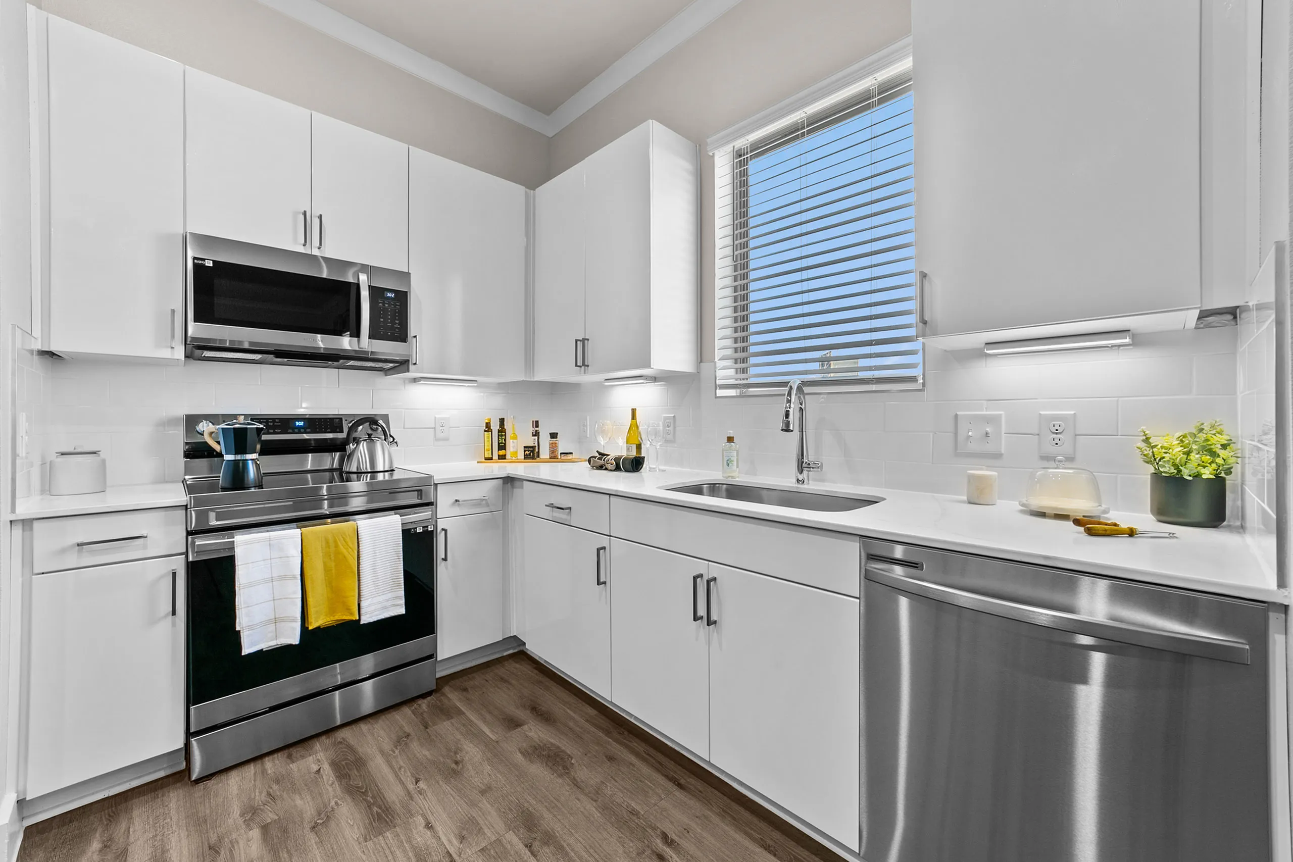 Sleek modern kitchen with stainless steel appliances, bright white cabinets, and elegant countertops, creating an inviting culinary space.