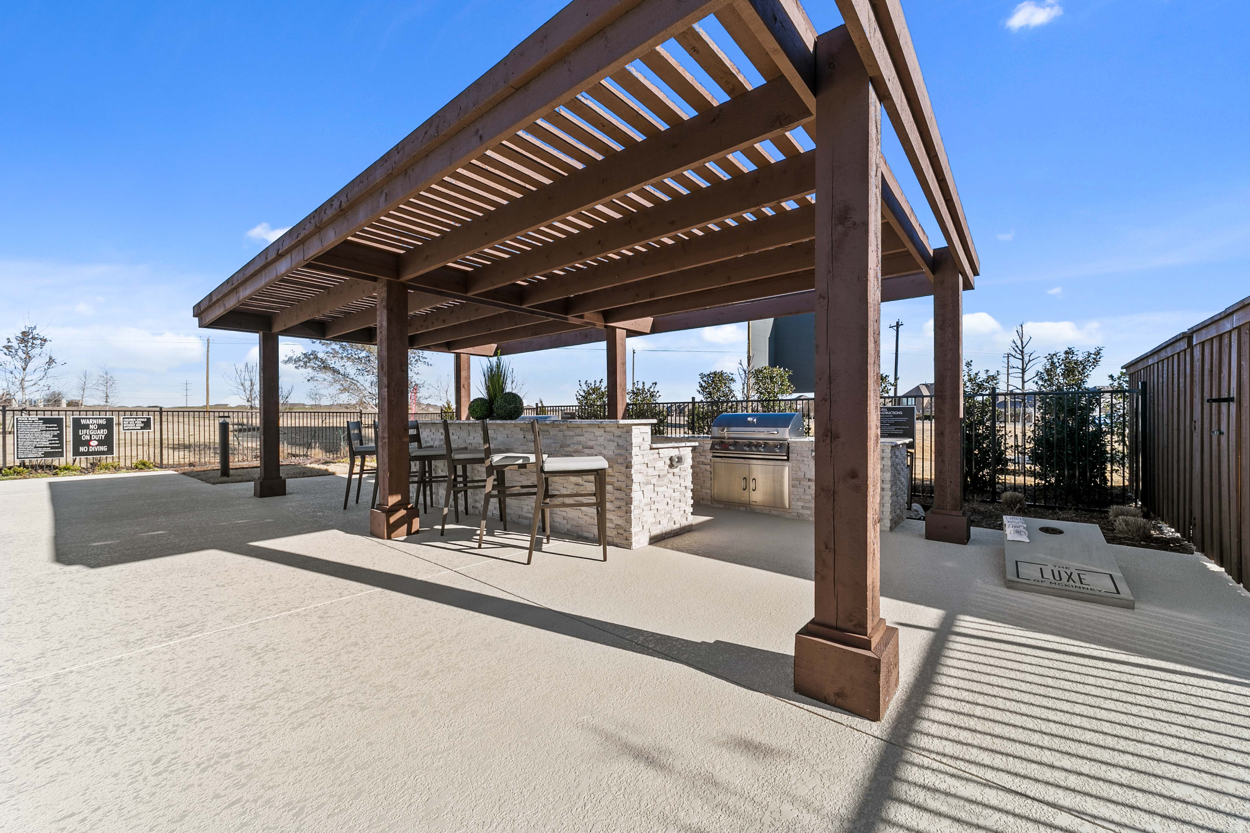 Trellis-Covered Outdoor Kitchen & Conversational Fireplace Lounge