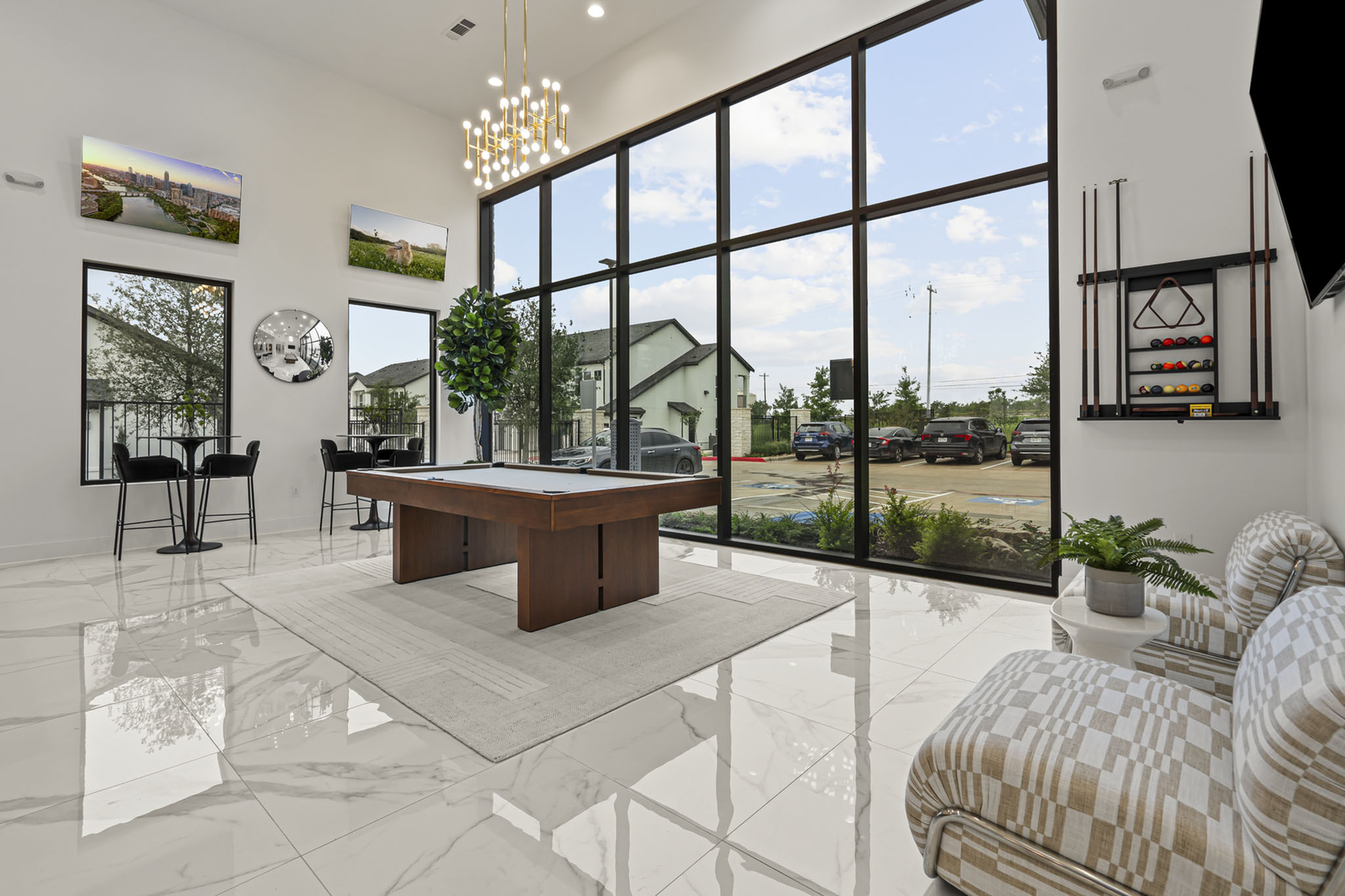 Luxurious modern lounge with tall windows, stylish pool table, chic seating, and elegant decor, offering abundant natural light.