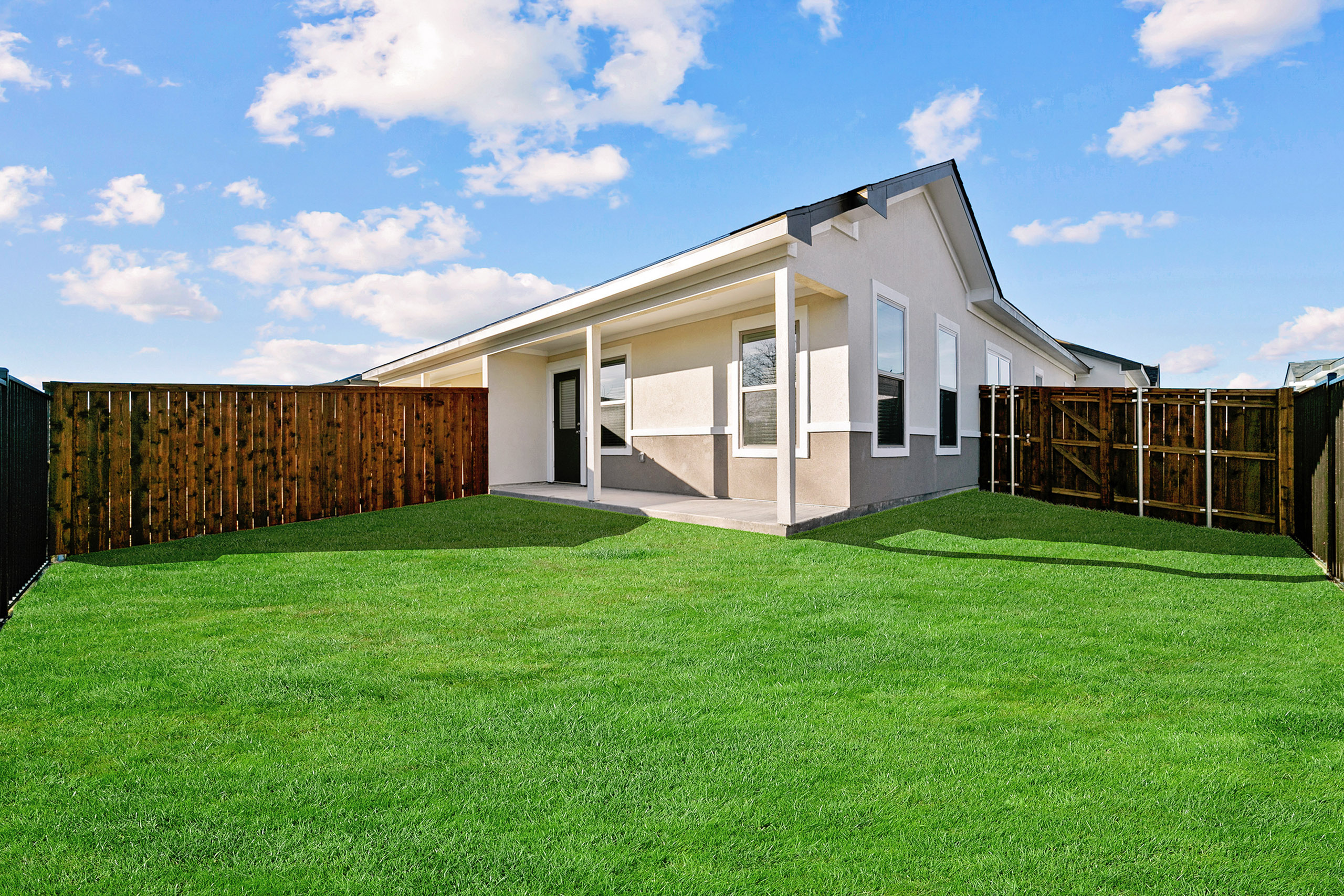 Charming single-story home with a lush green backyard, fenced privacy, and a welcoming covered patio.