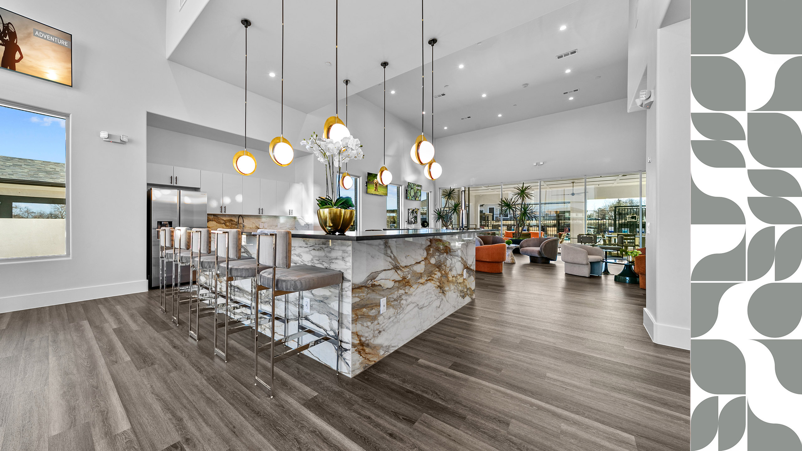 Luxurious open-concept clubhouse with marble countertops, modern lighting, and stylish bar seating.