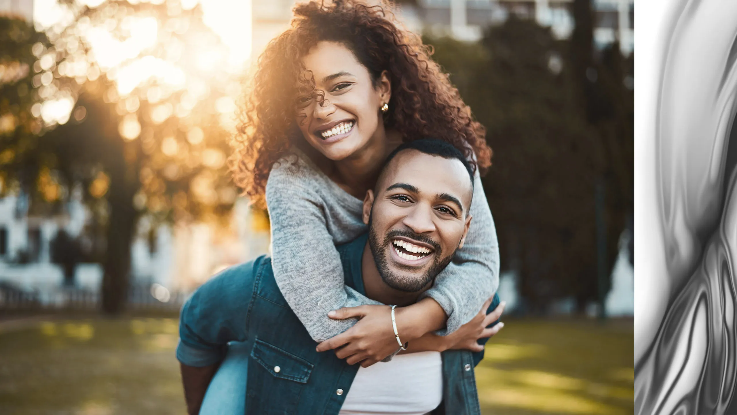 Joyful couple enjoying a sunny day outdoors, exuding happiness and warmth.