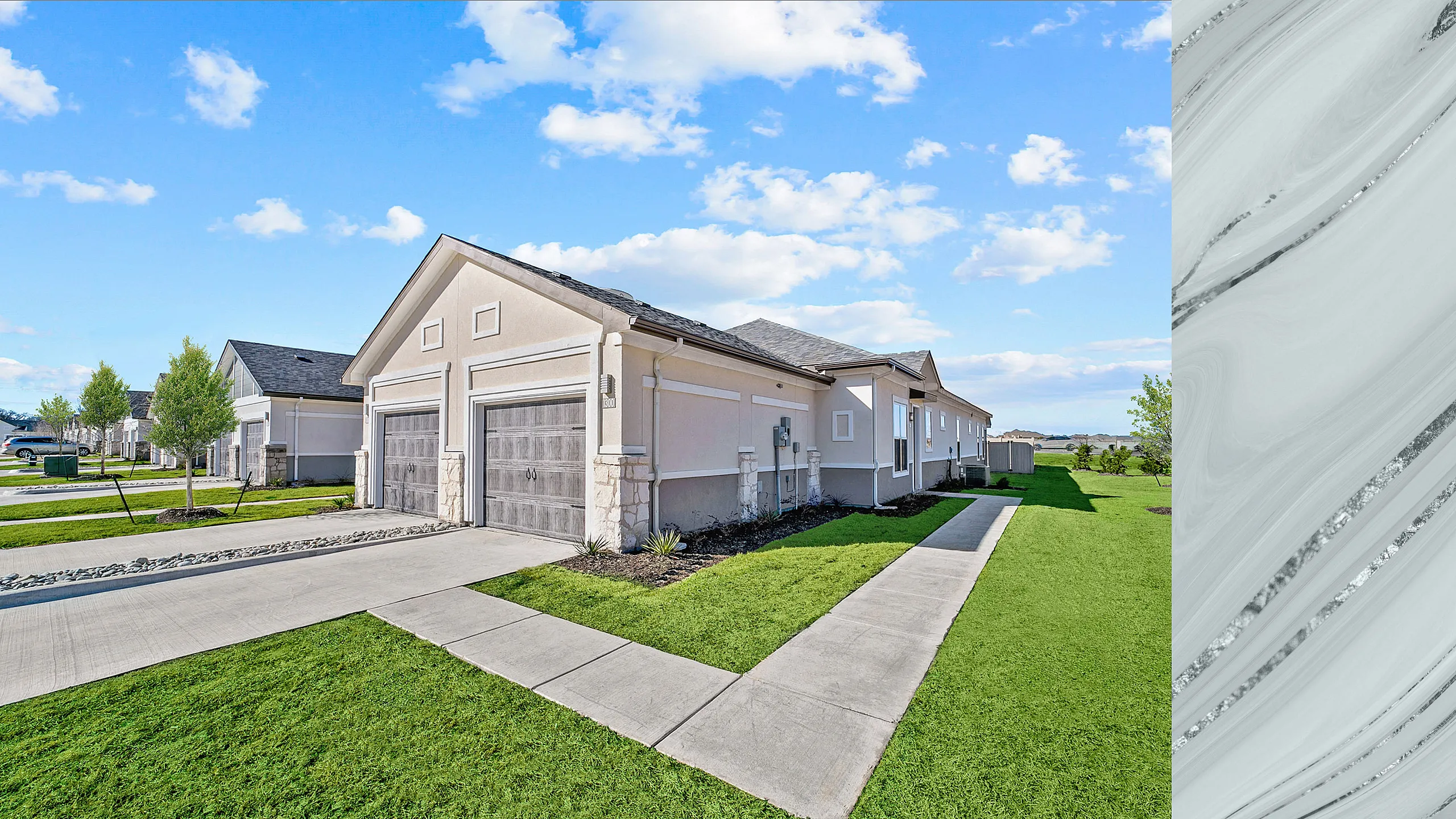 Elegant suburban home with dual garages and lush green lawn under a clear blue sky.