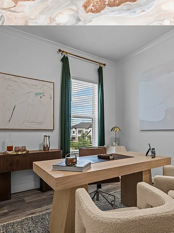 Elegant and modern home office with stylish wooden desk, plush chairs, and artistic decor, bathed in natural light from large windows.
