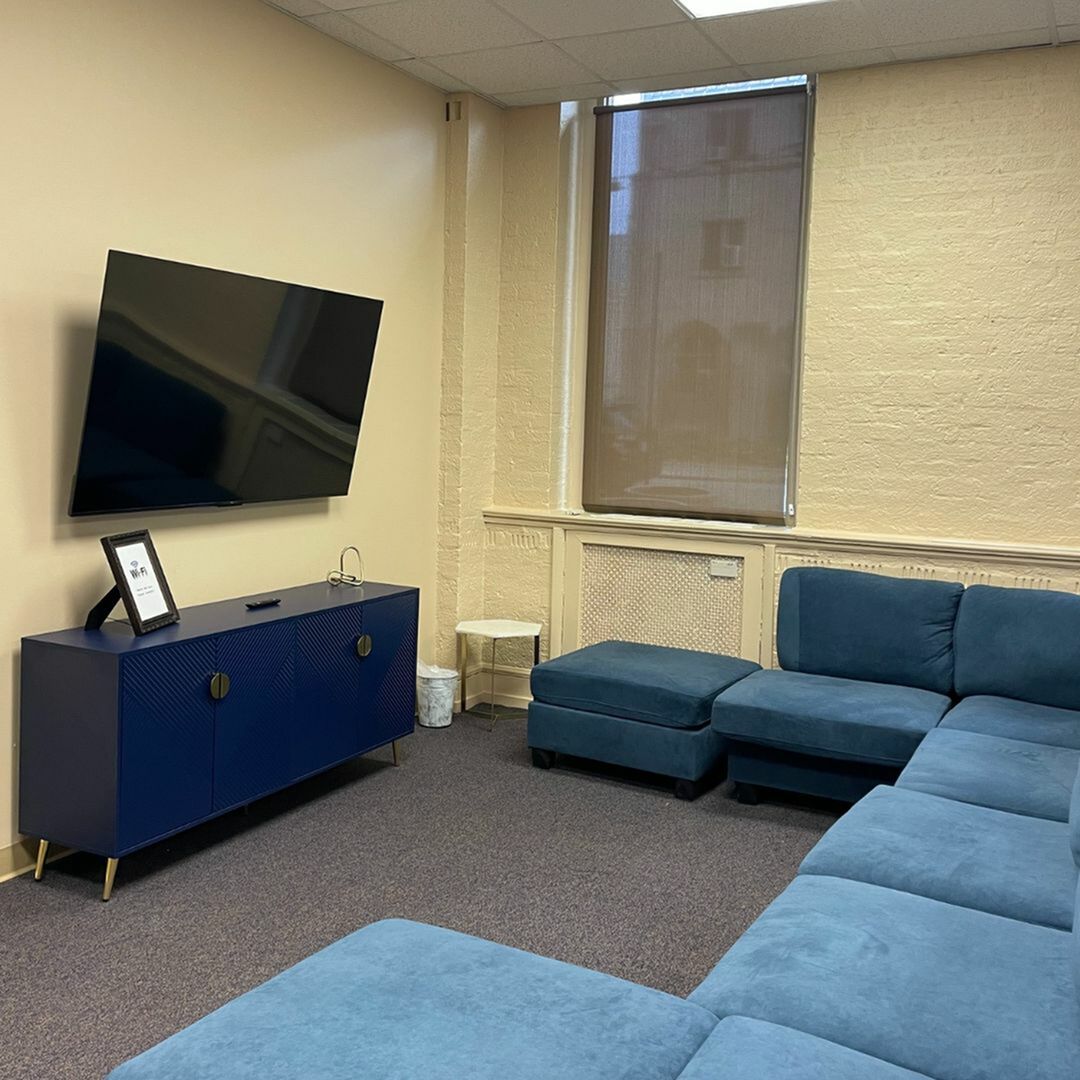 Inviting living room with plush blue sectional sofa, modern TV unit, and ambient lighting.