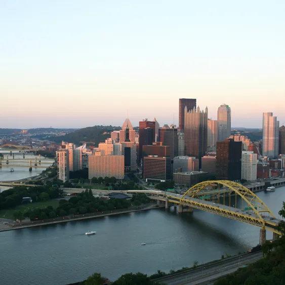 Breathtaking cityscape showcasing a vibrant skyline and iconic yellow bridge over a serene river, perfect for urban living.