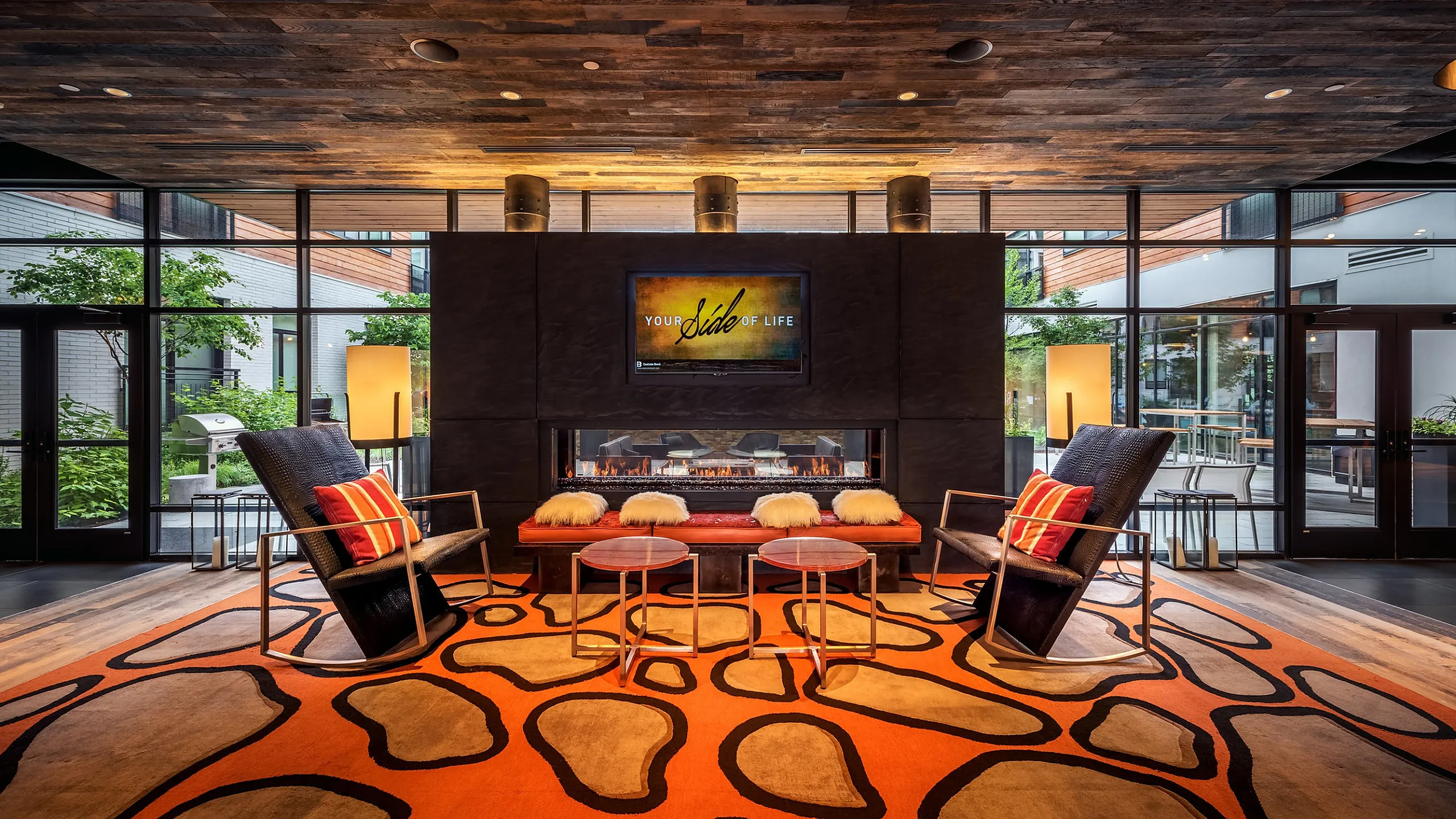 Stylish lounge space with cozy seating, a modern fireplace, and vibrant decor.