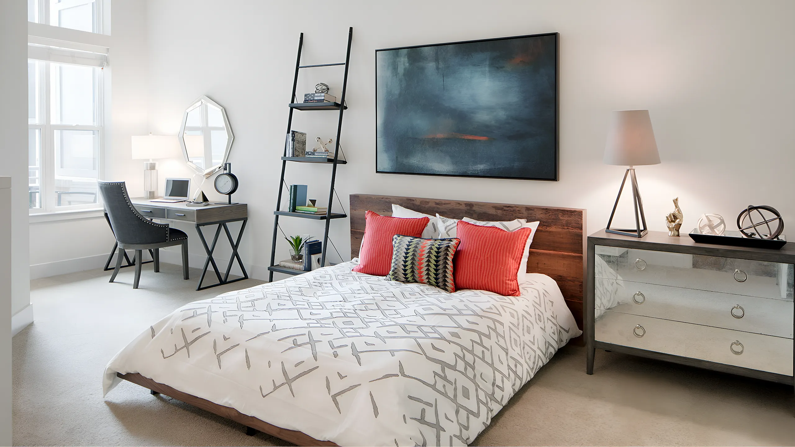 Stylish bedroom with modern decor, featuring a comfortable bed with geometric patterned bedding, a sleek ladder shelf, and a workspace by a large window.