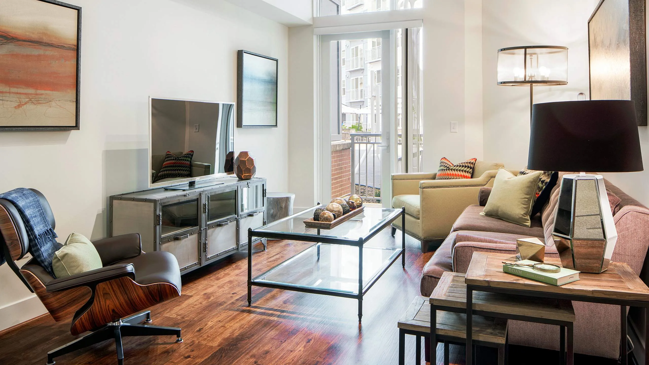 Contemporary living room with plush seating, elegant decor, and natural lighting through large windows.