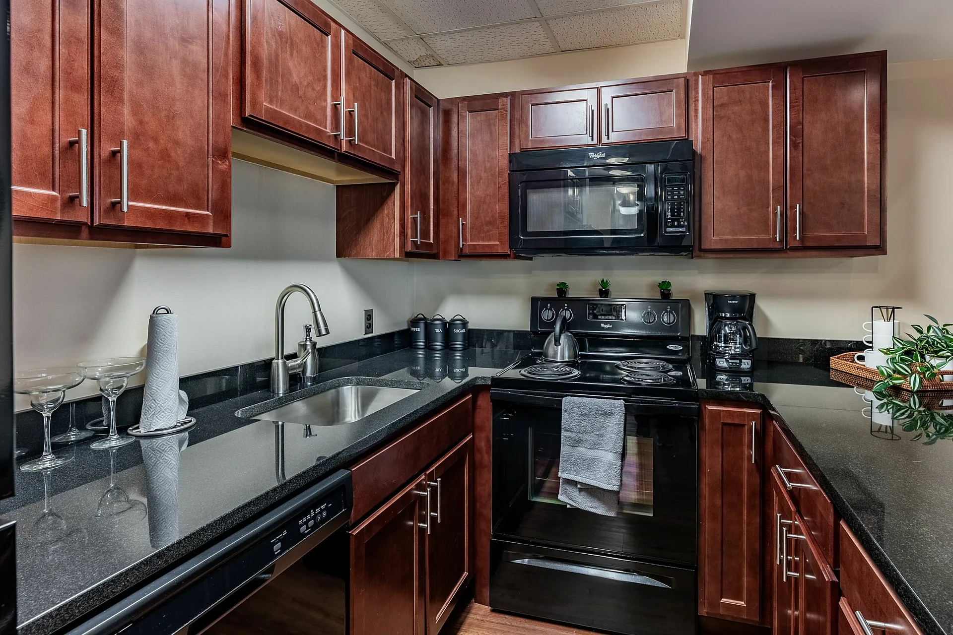 Modern kitchen with sleek granite countertops, rich wooden cabinetry, and stainless steel appliances.