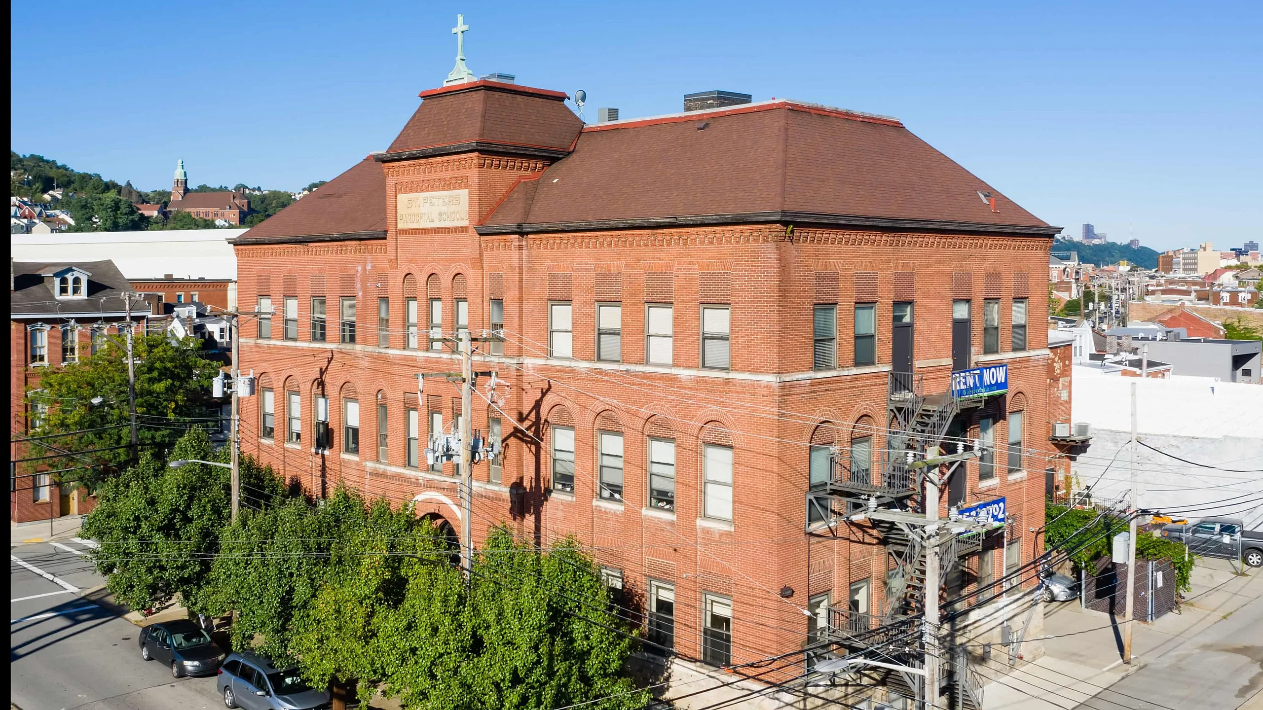 Charming historic brick building with large windows, nestled in a vibrant urban neighborhood, now available for rent.
