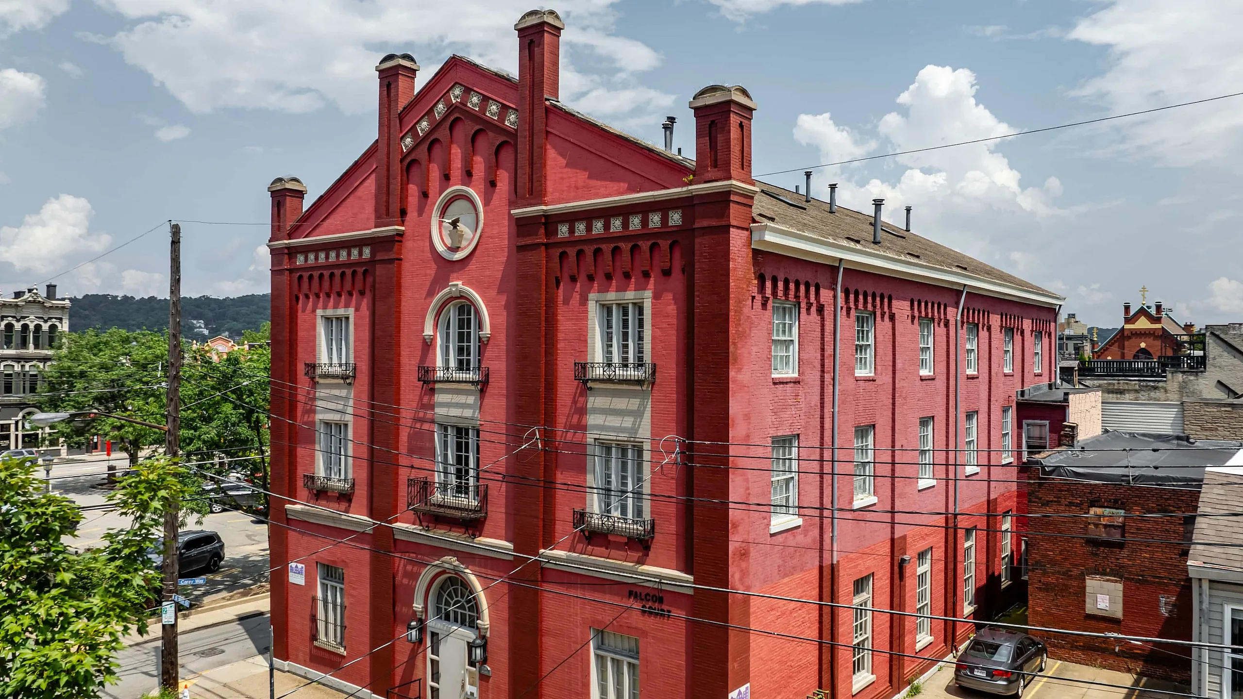 Charming historic red brick building with elegant architectural details in a vibrant urban setting.