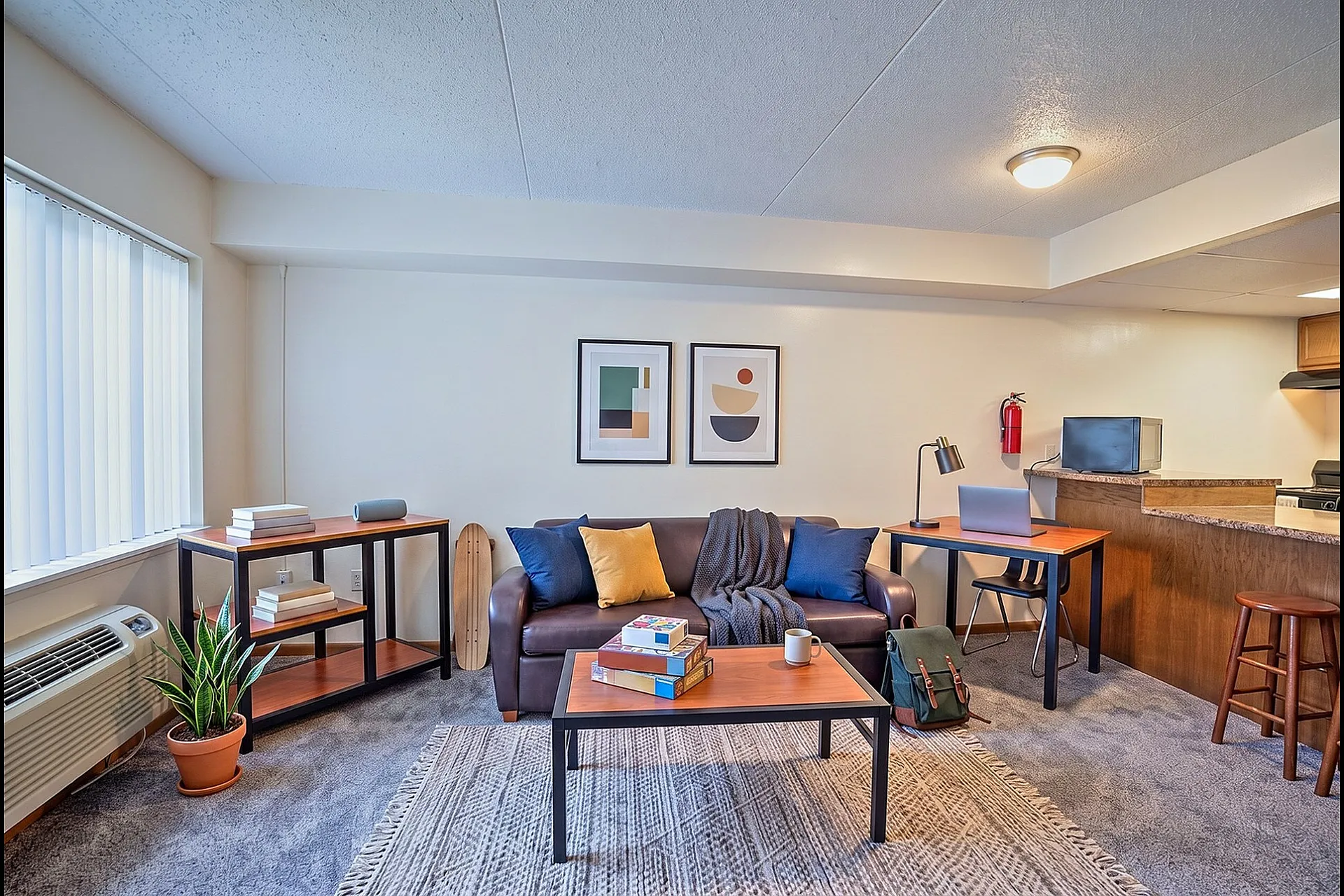 Inviting state college apartment living room with cozy seating, modern decor, natural lighting, and a welcoming home office corner.