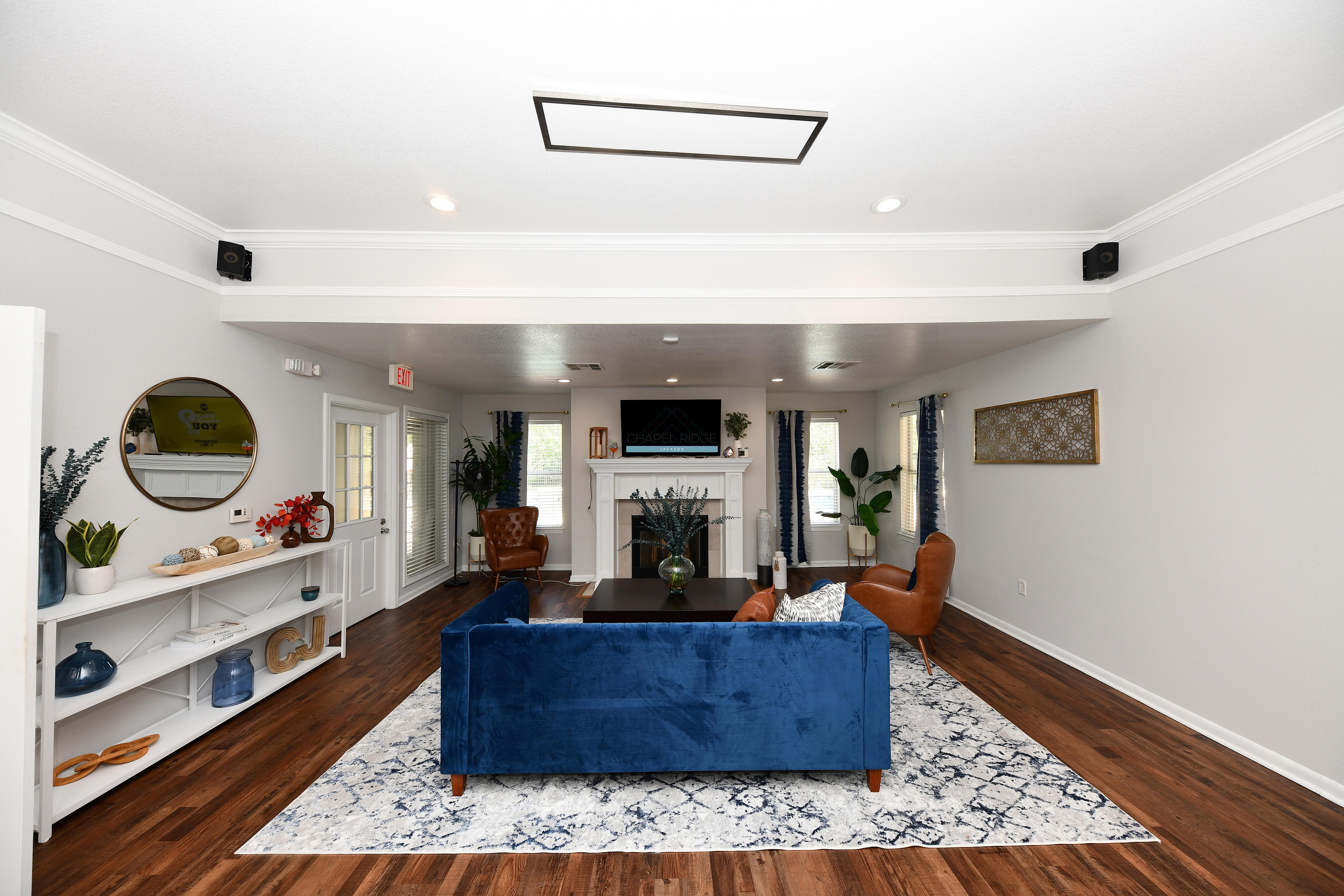 Elegant living room with a plush blue sofa, stylish leather chairs, and a chic fireplace centerpiece.
