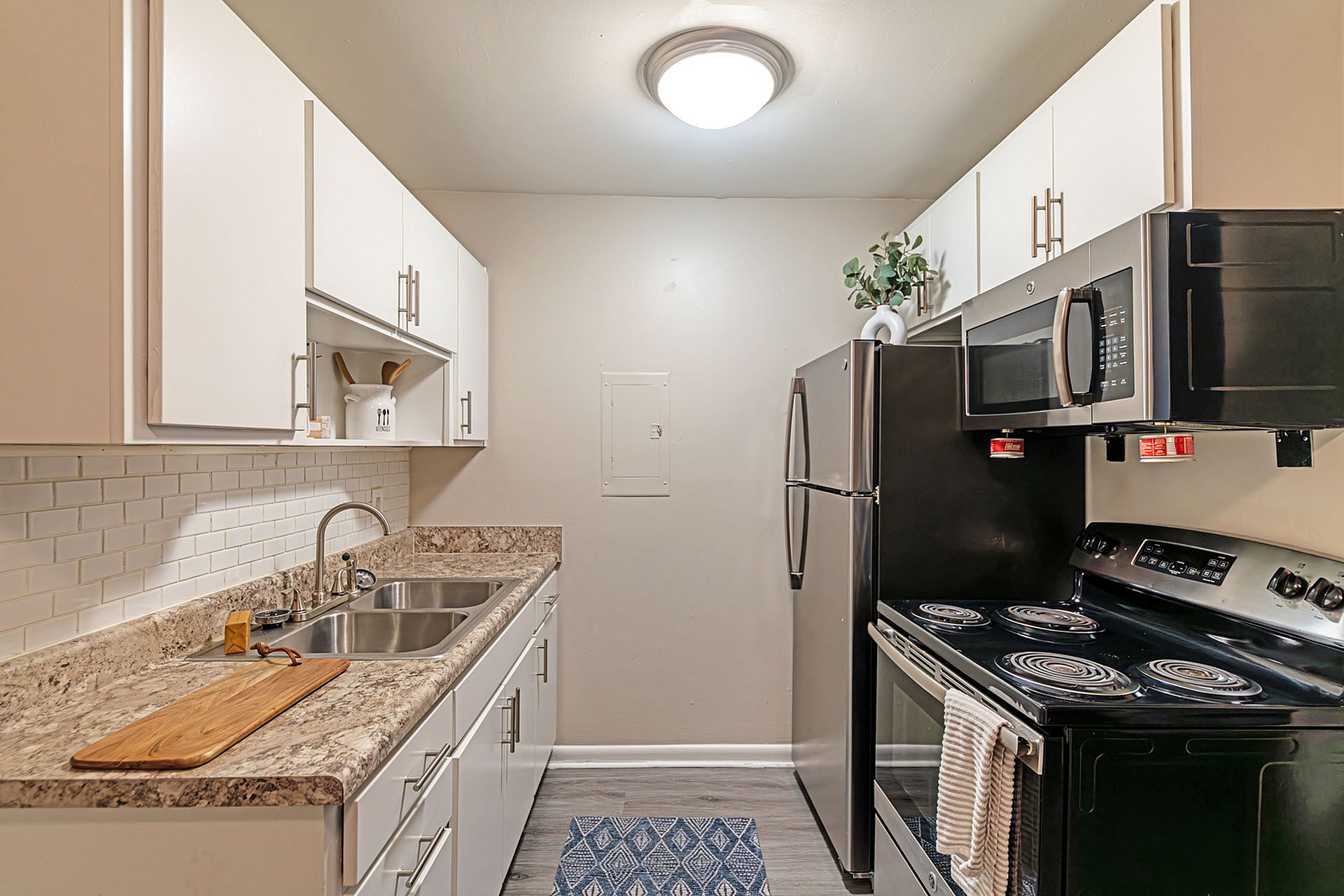 Modern kitchen with sleek stainless steel appliances, white cabinetry, and elegant countertops.