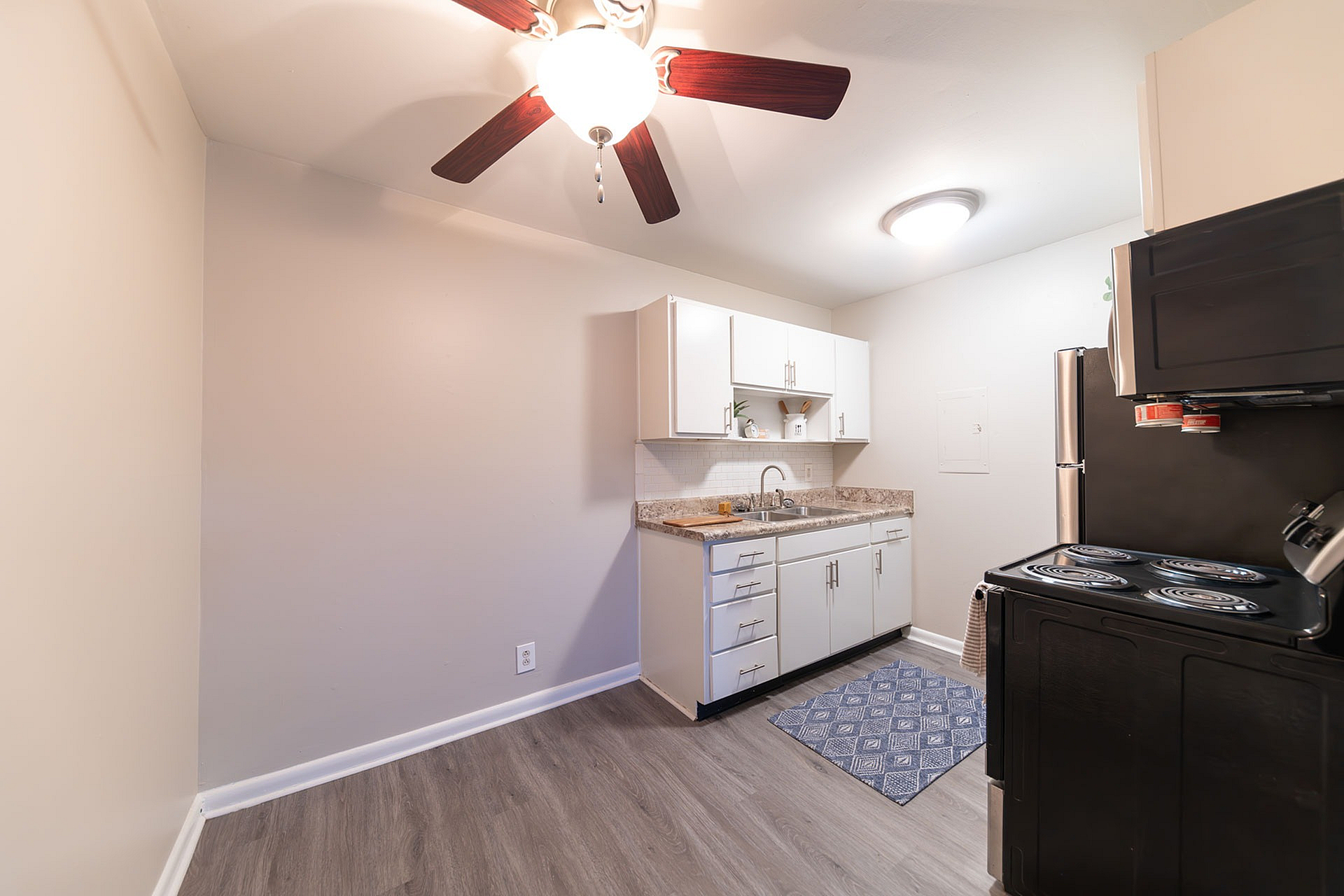 Modern kitchen with sleek white cabinets, elegant countertop, and stainless steel appliances.