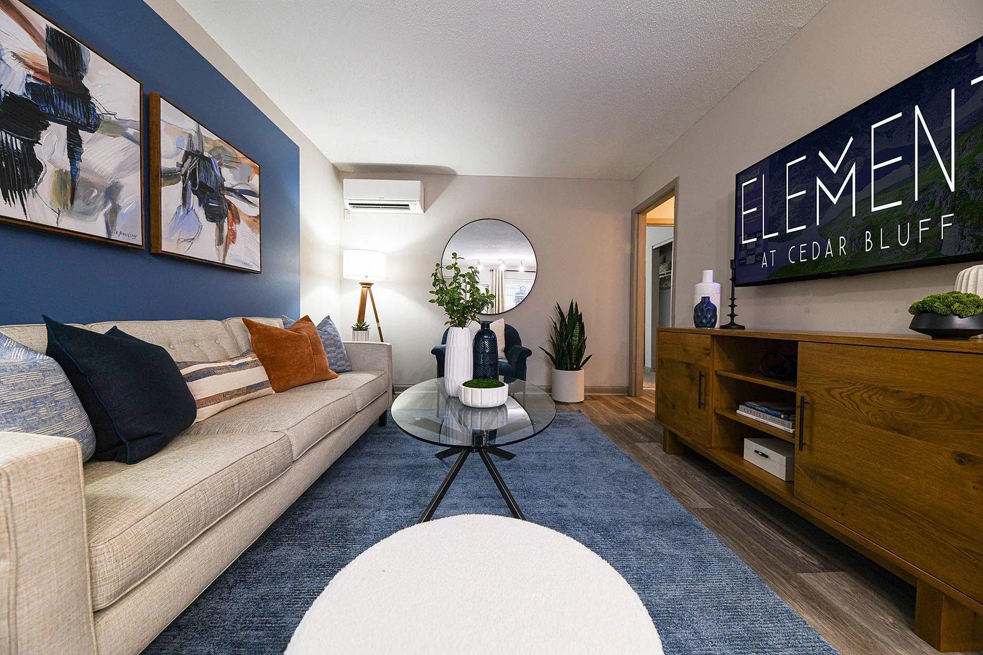 Inviting living room with modern decor, featuring a plush sofa, stylish artwork, and elegant wooden furniture.