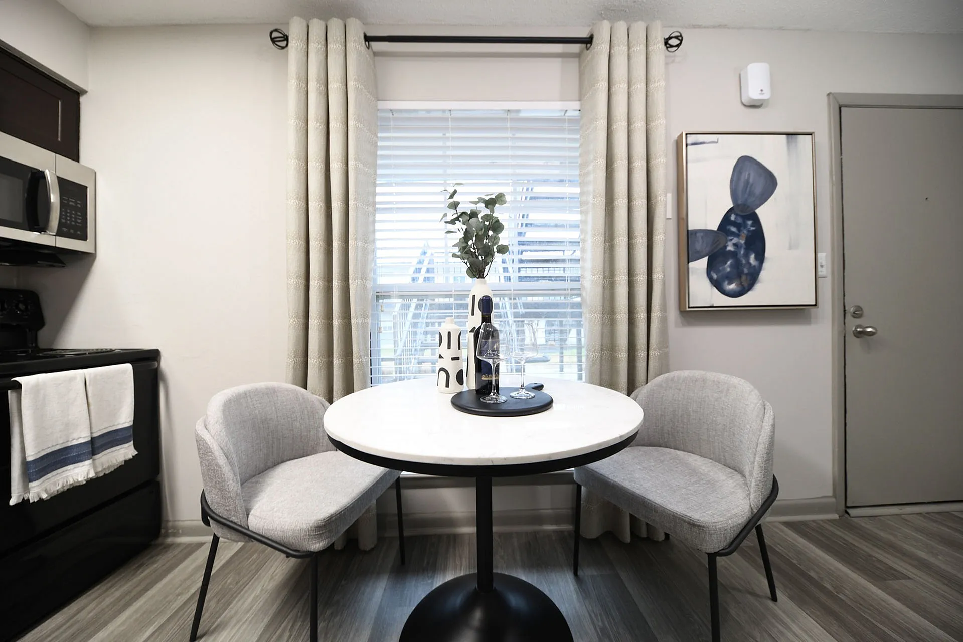 Cozy dining area with a round table, modern chairs, and elegant decor, featuring a stylish kitchen setting.