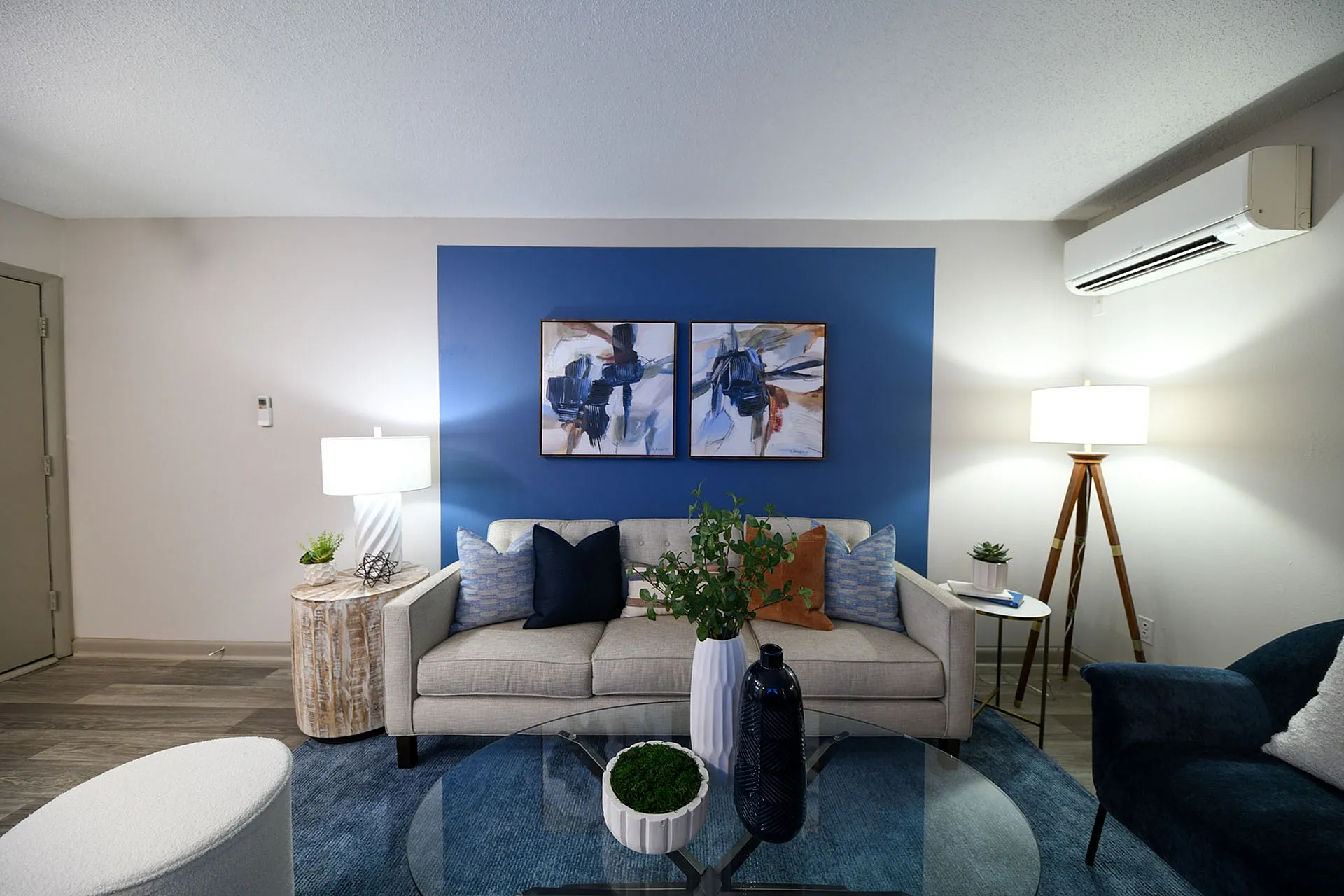 Stylish living room with modern decor, featuring a cozy sofa, abstract art, and accent lighting.