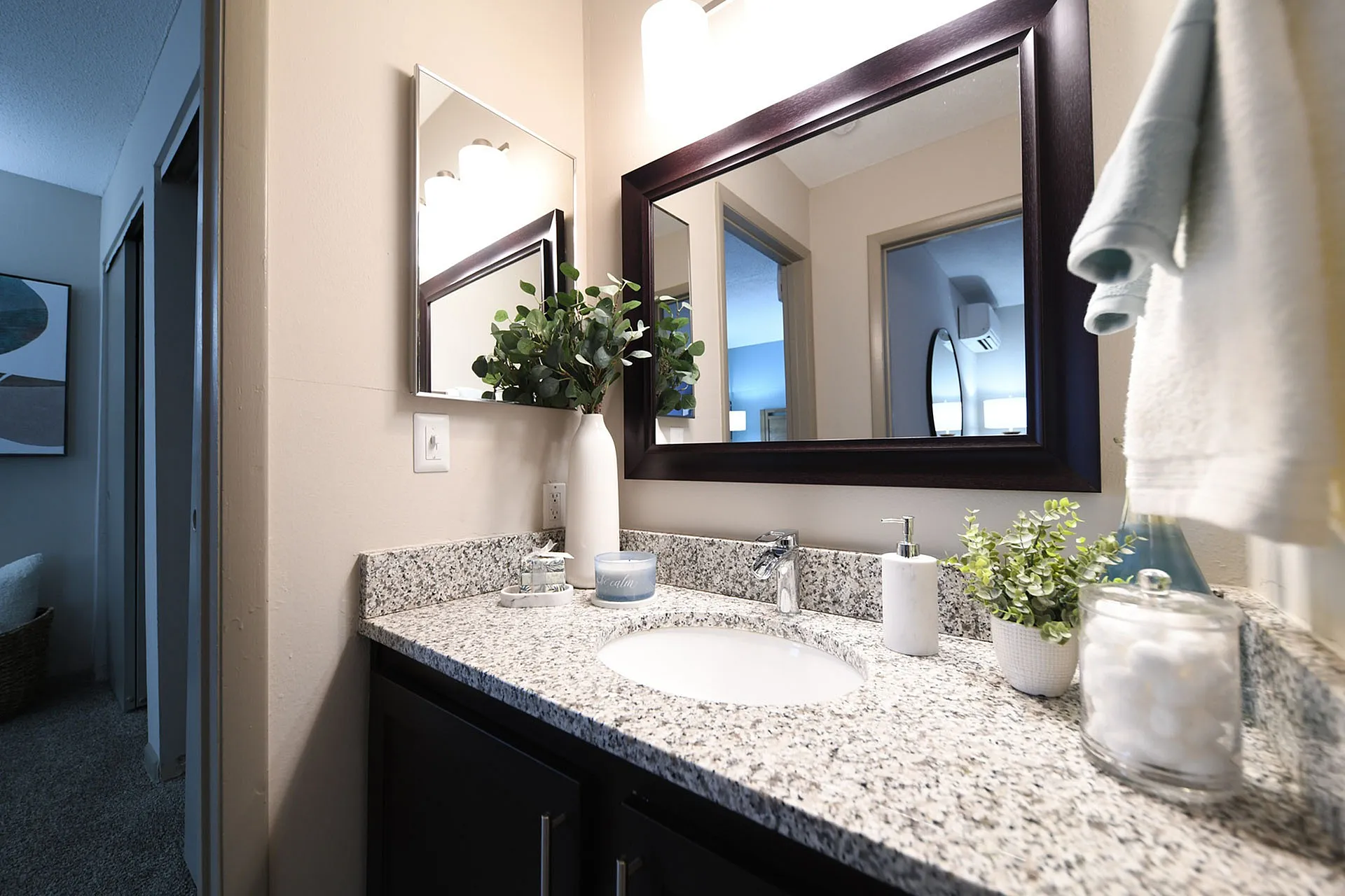 Chic bathroom vanity with granite countertop and stylish mirror.