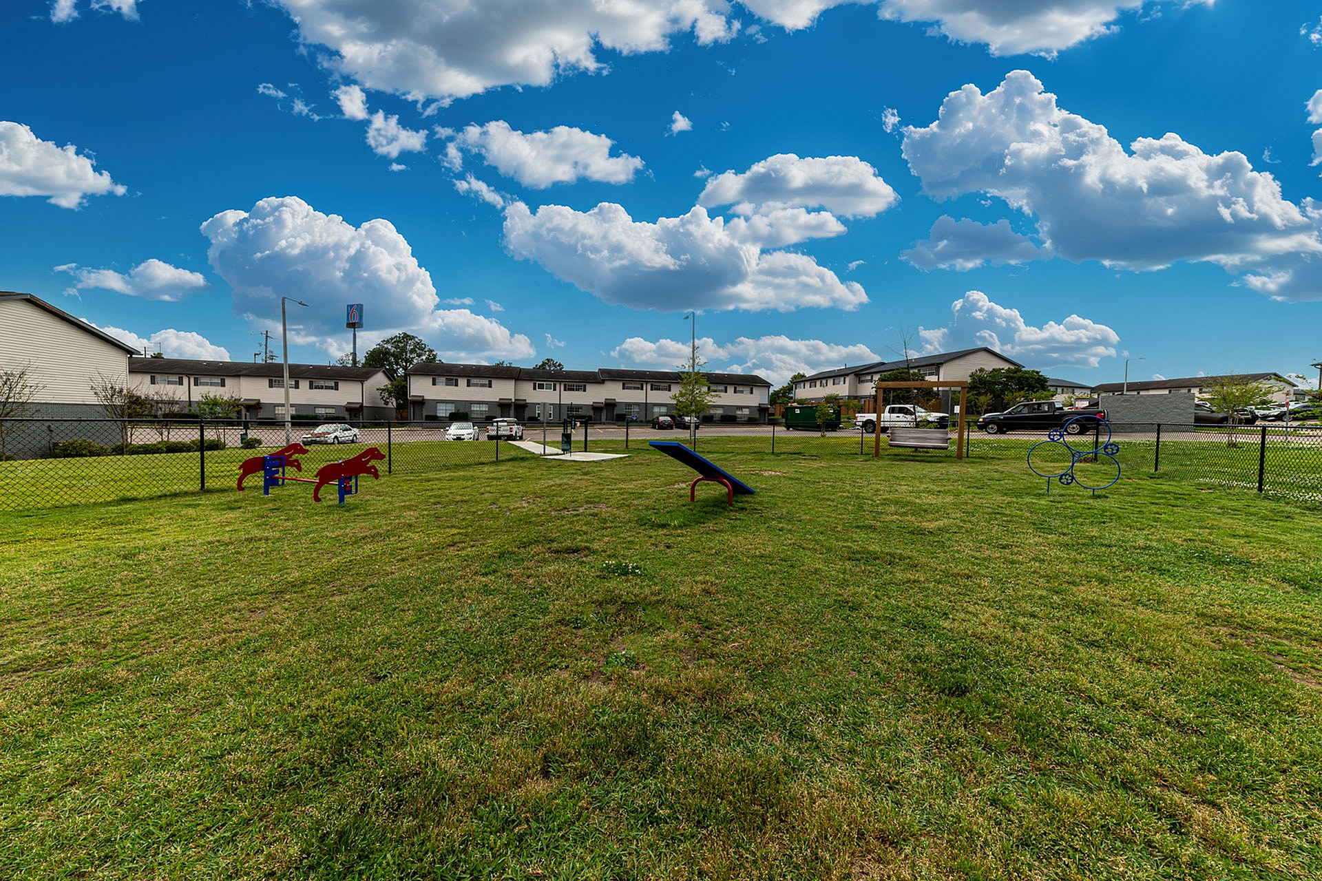 Inviting outdoor play area with vibrant equipment under a bright blue sky, perfect for kids and families in this welcoming apartment community.