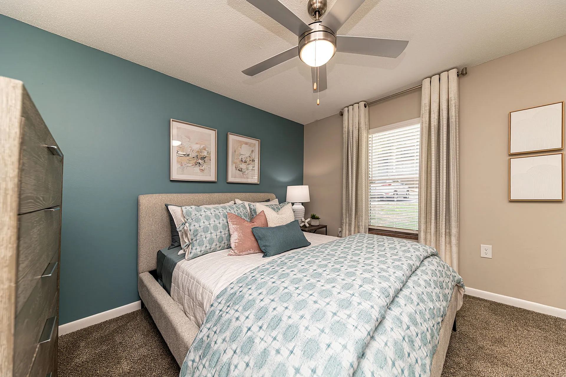 Inviting bedroom with modern decor, featuring a cozy bed, elegant teal accent wall, and soft lighting.