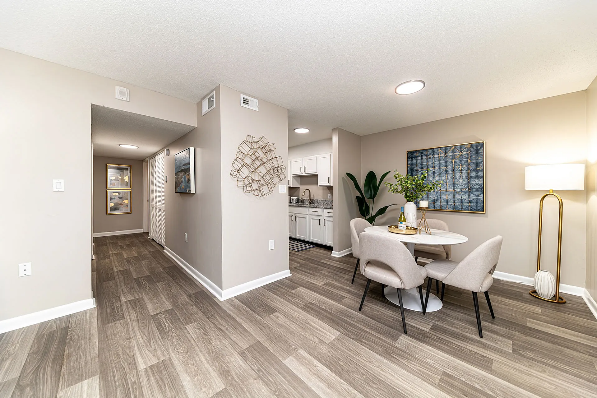 Elegant apartment dining area with modern decor, featuring stylish wood flooring, a cozy dining set, and an inviting open layout.