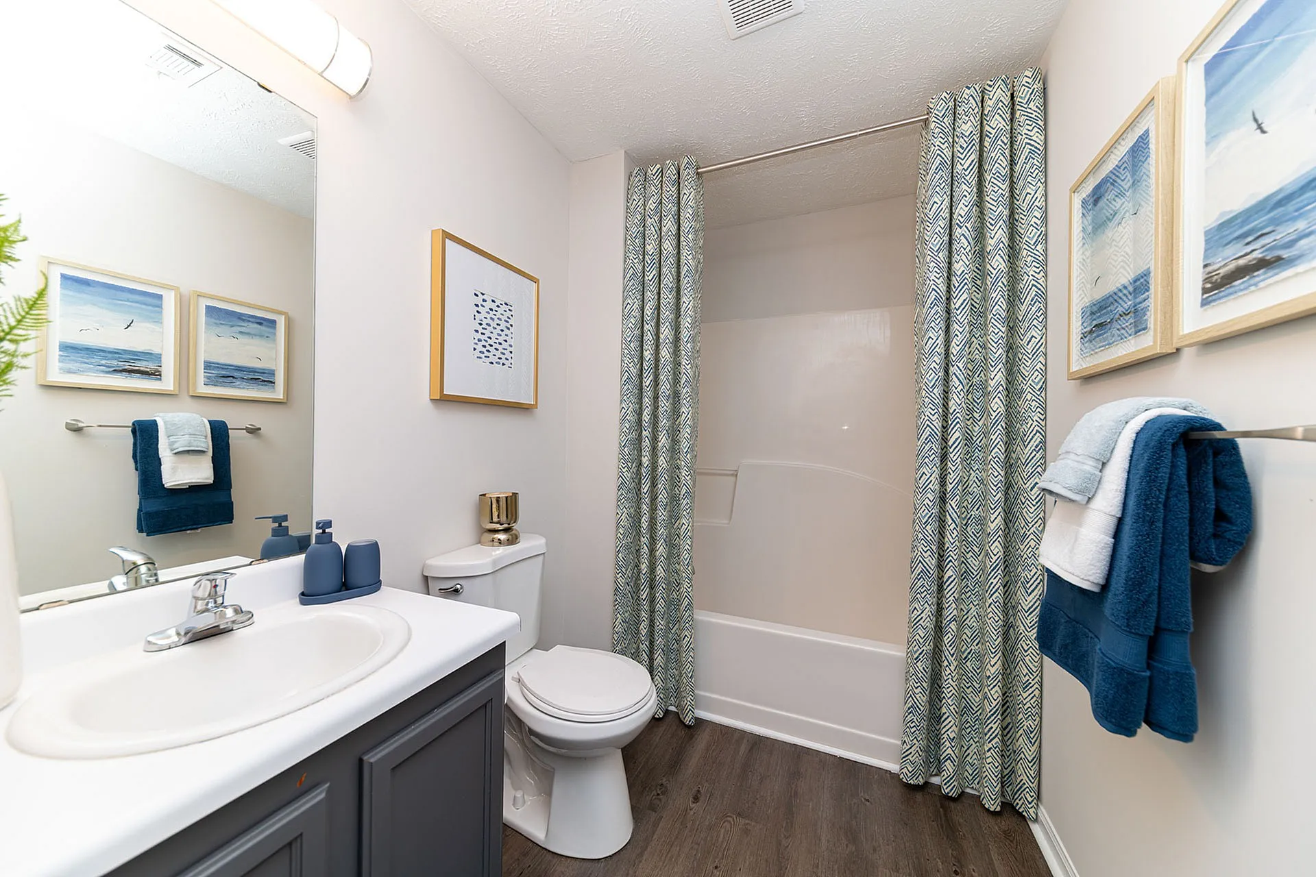 Chic and modern bathroom with elegant decor, featuring a sleek vanity, stylish artwork, and plush towels for a spa-like ambiance.