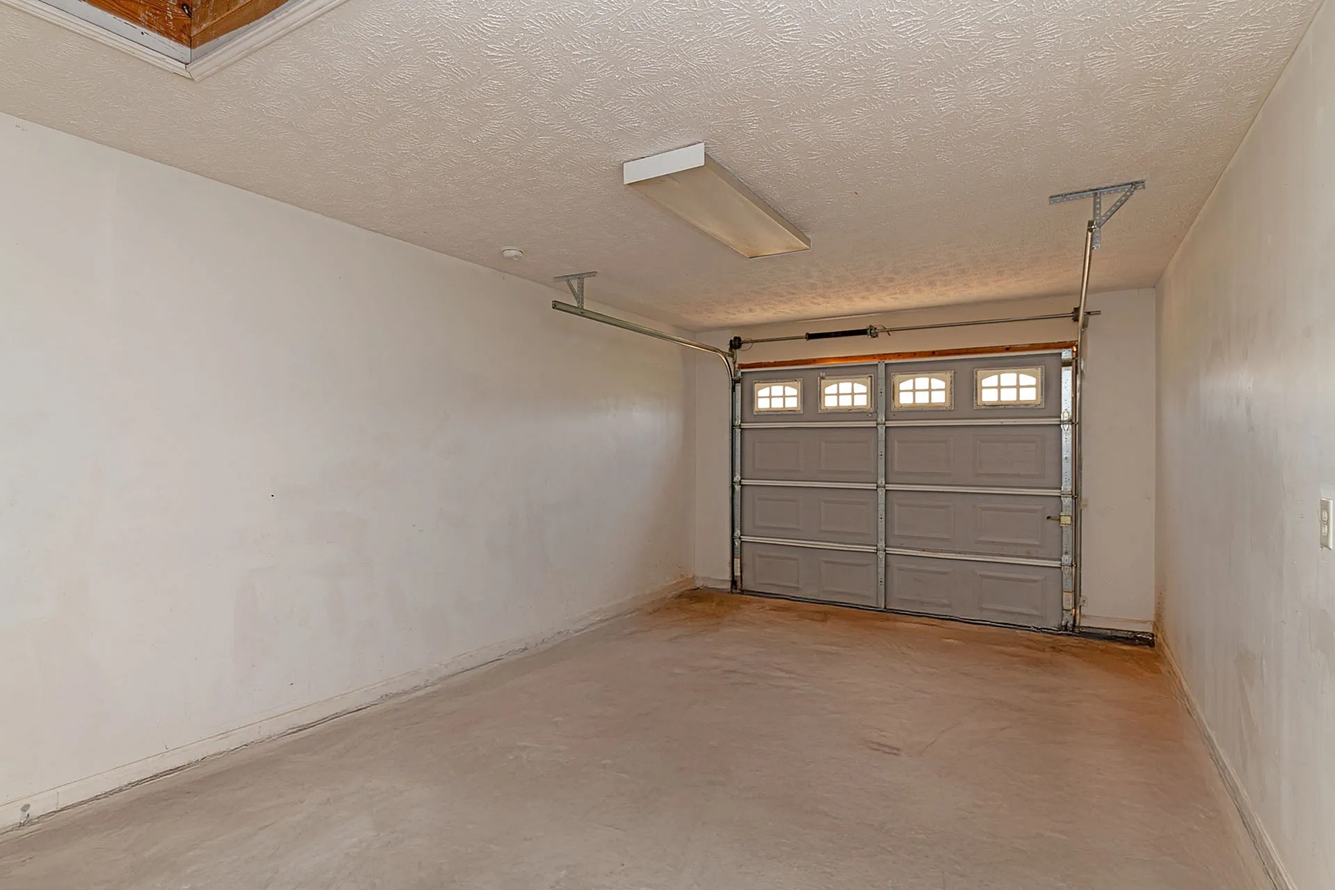 Spacious garage with a sleek automatic door, perfect for secure parking and additional storage.