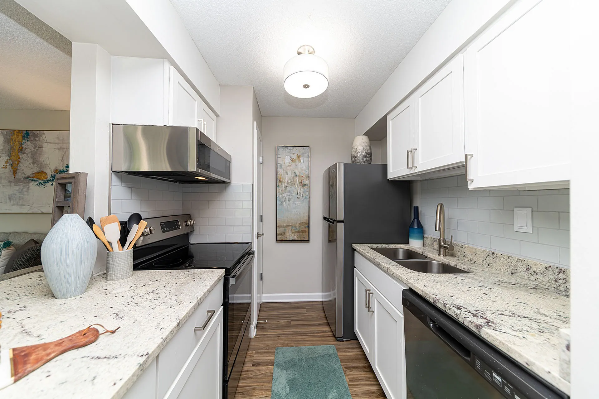 Modern kitchen with sleek granite countertops, stainless steel appliances, and elegant white cabinetry for a stylish cooking experience.