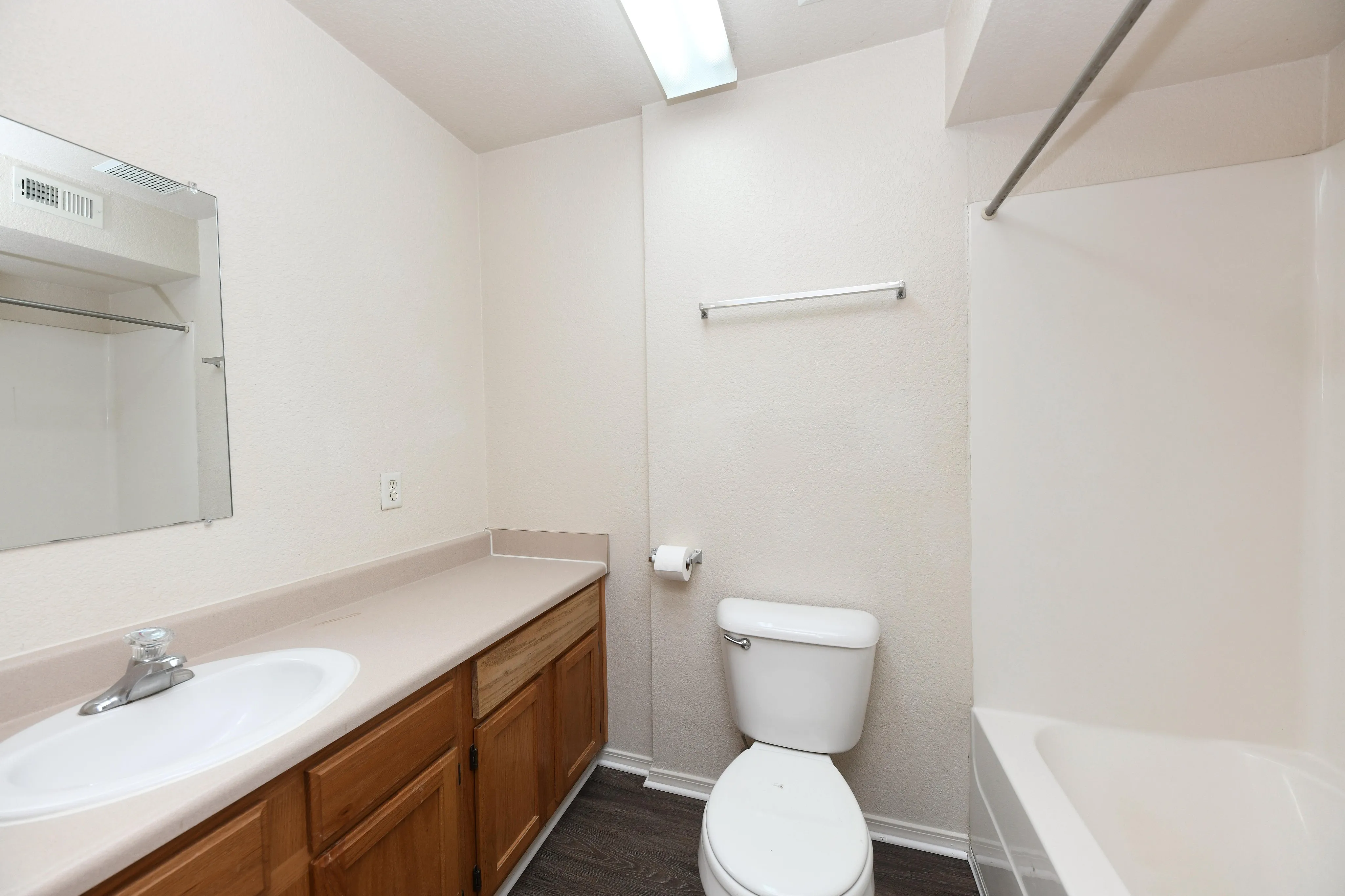 Bright, spacious bathroom featuring a sleek countertop, modern fixtures, and a pristine bathtub.