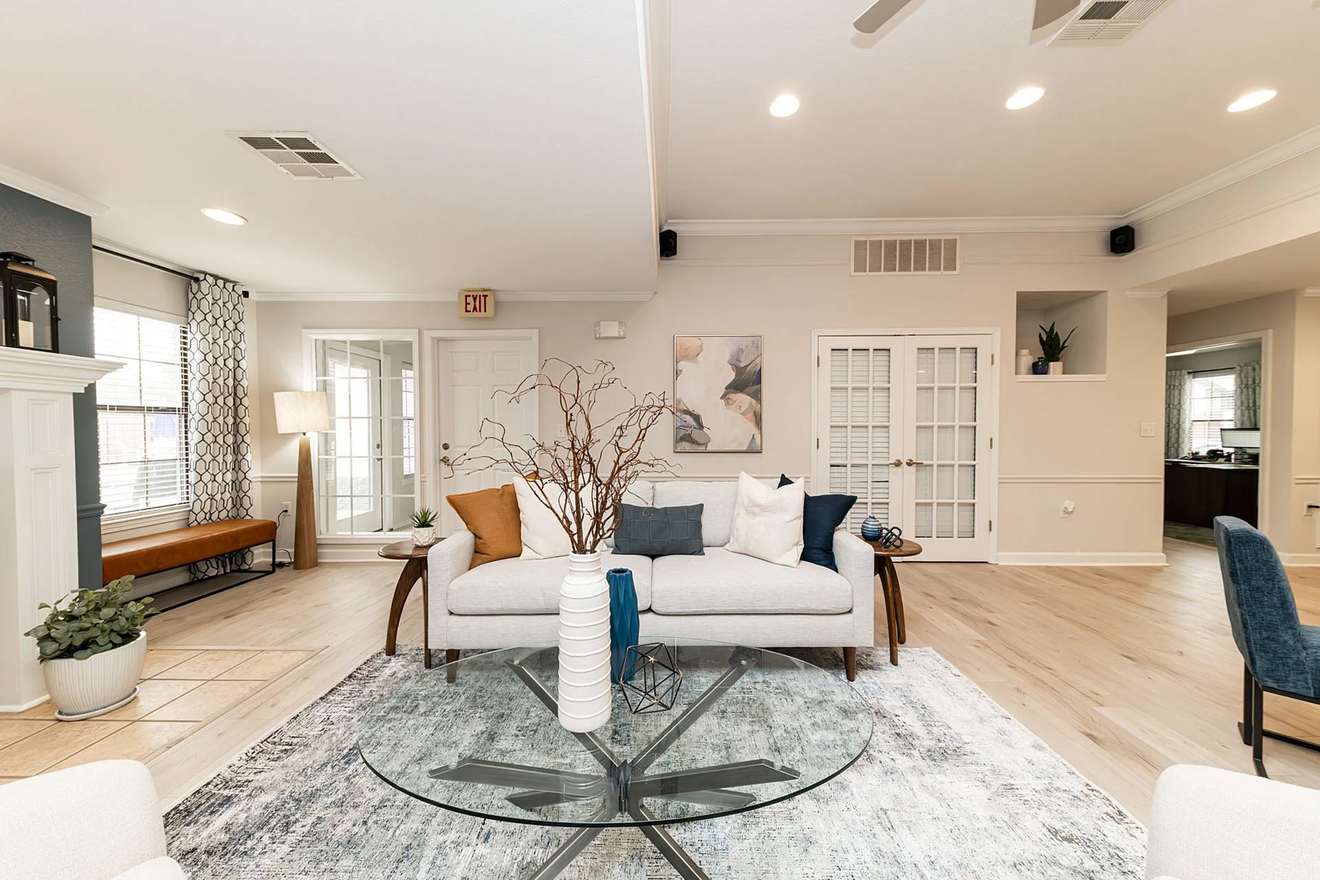 Bright and inviting living room with stylish decor, featuring a cozy sofa, elegant glass coffee table, and natural light streaming through large windows.